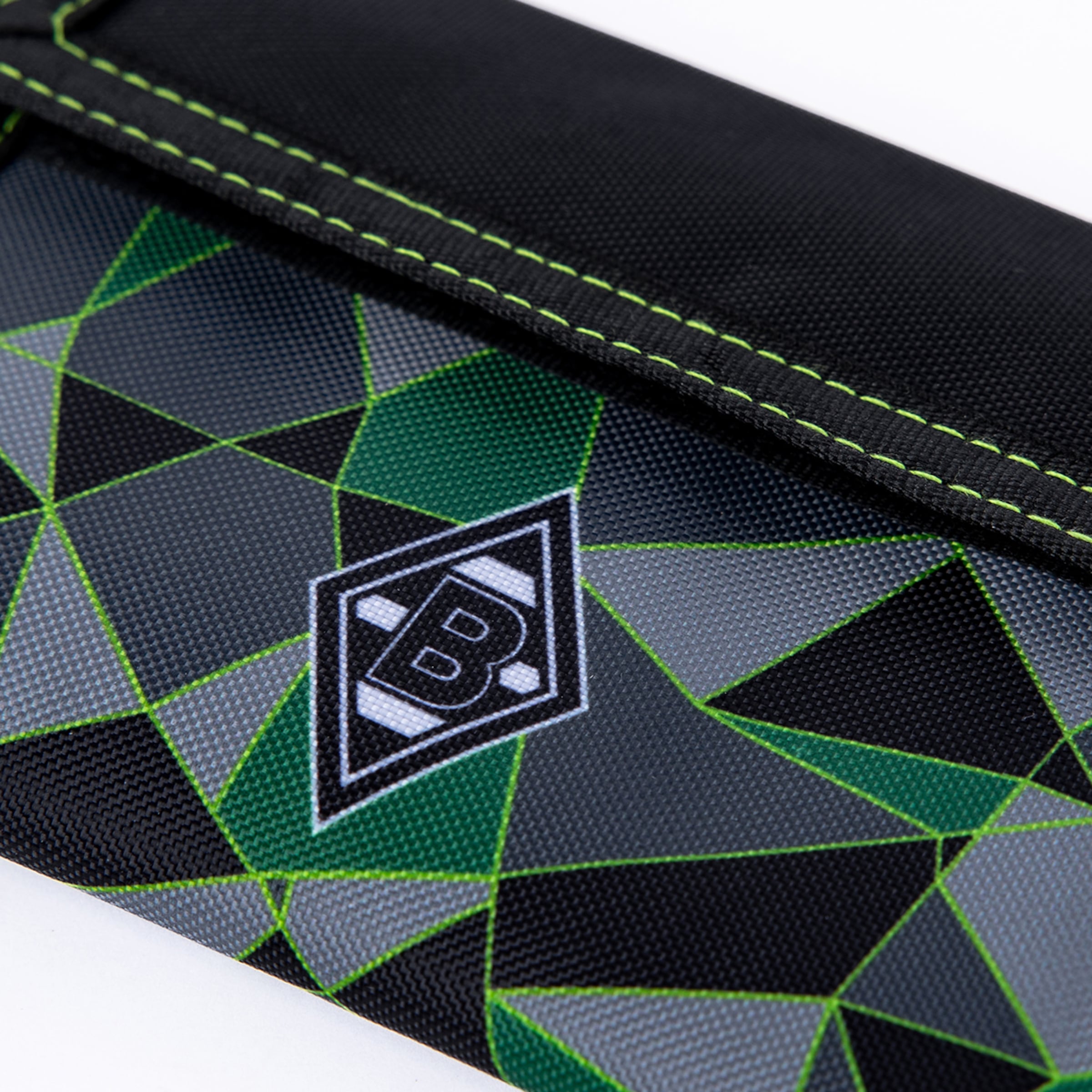 Close-up of a textile pouch with a geometric pattern in black, grey, and green, featuring bright green stitching and a white Borussia Mönchengladbach logo with a 'B' and two 'D's.
