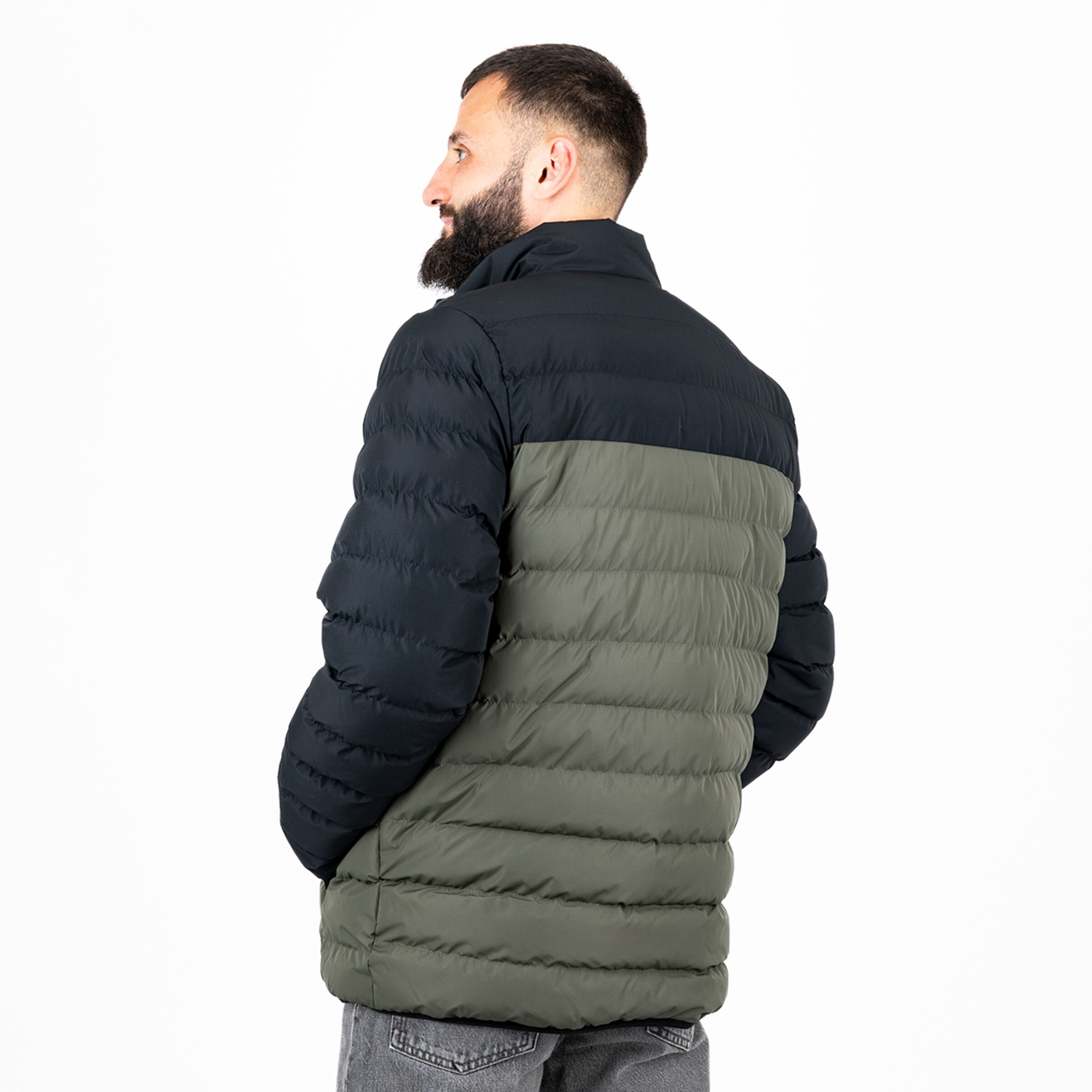 Herr trägt eine gesteppte Jacke in Schwarz und Olivgrün von hinten.
