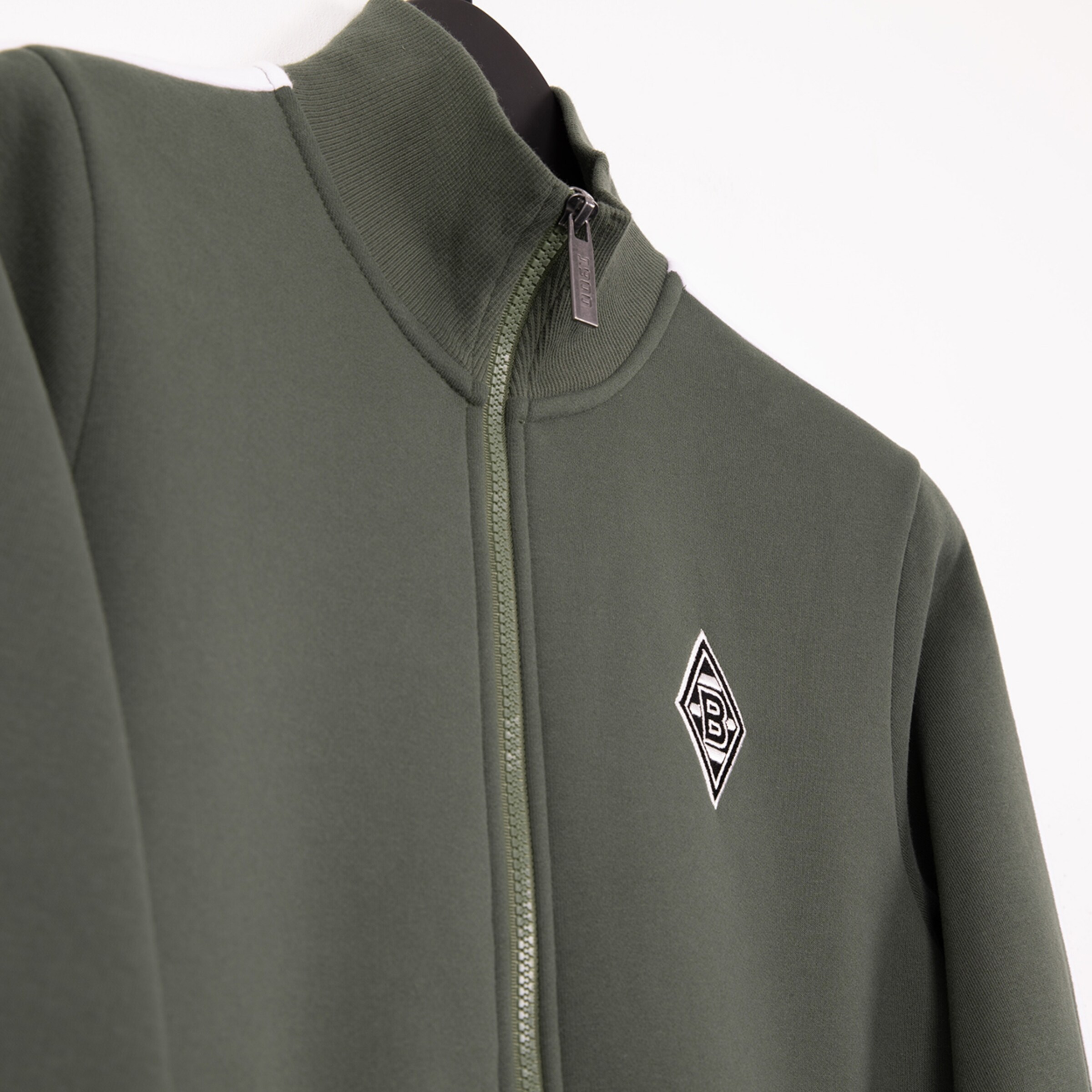 Dunkelgrüne Trainingsjacke mit Reißverschluss und dem Borussia Mönchengladbach-Logo.
