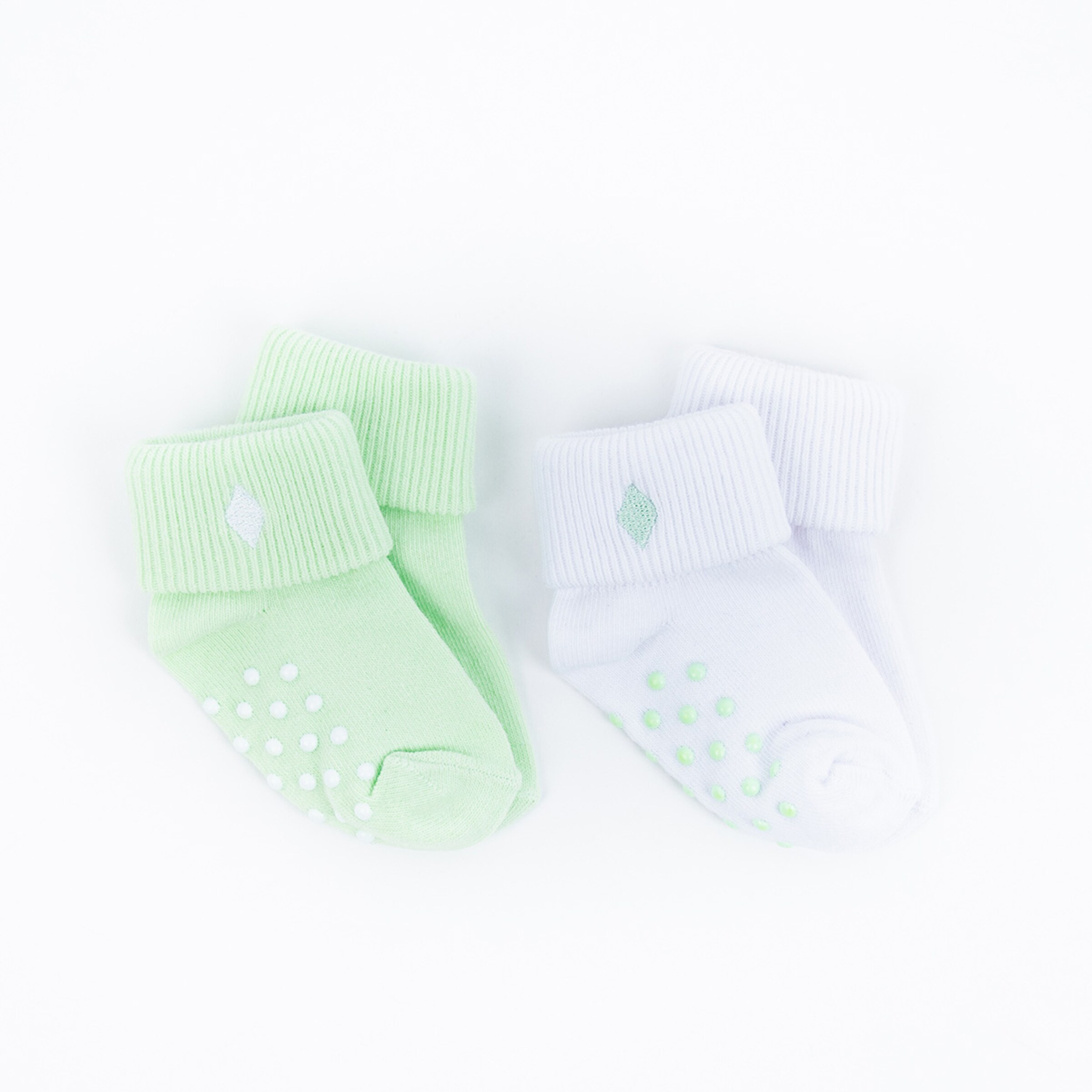 Grüne und weiße Babysocken mit rutschfesten Punkten auf der Unterseite