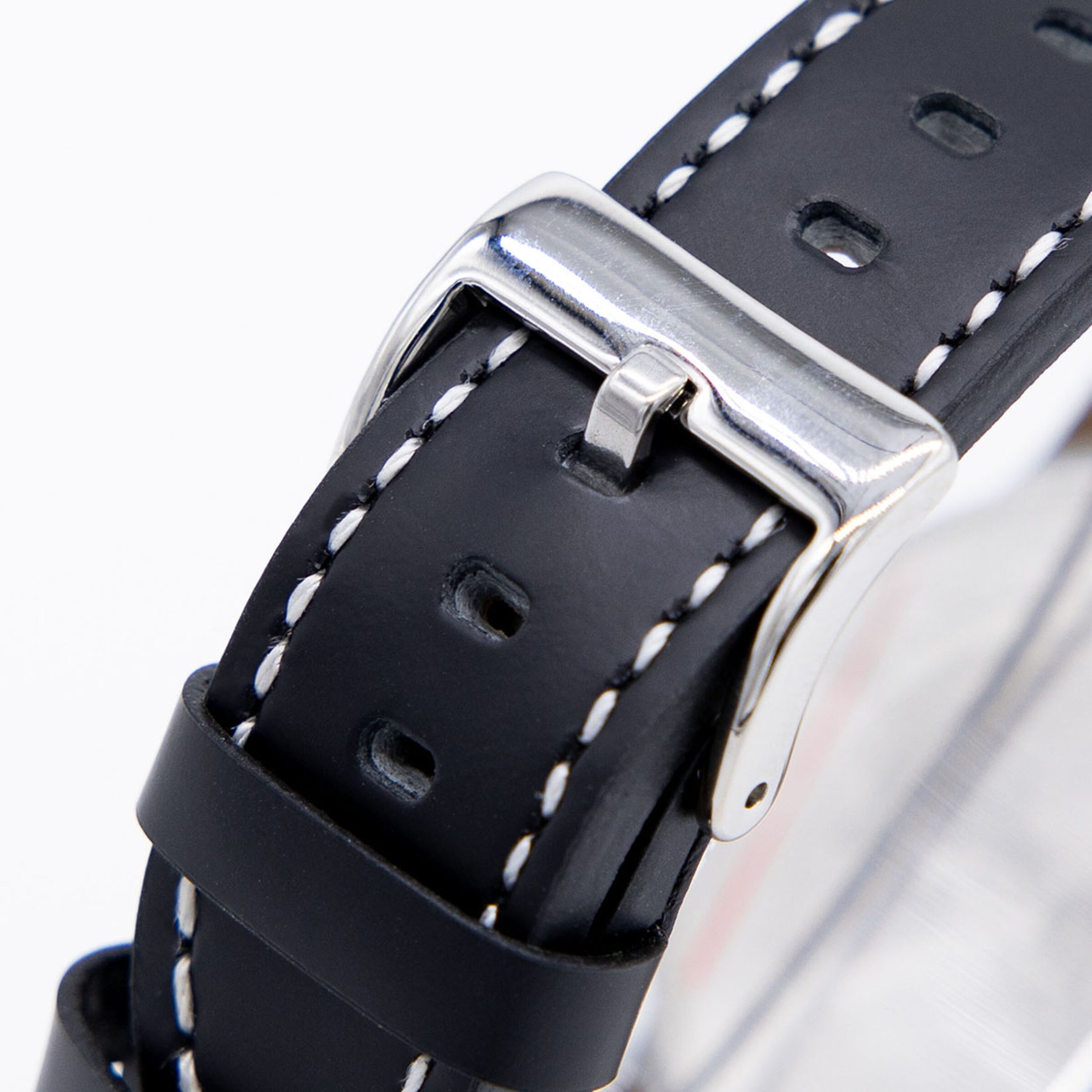 Nahaufnahme eines schwarzen Leder-Uhrenarmbands mit weißer Kontrastnaht und silberner Dornschließe.