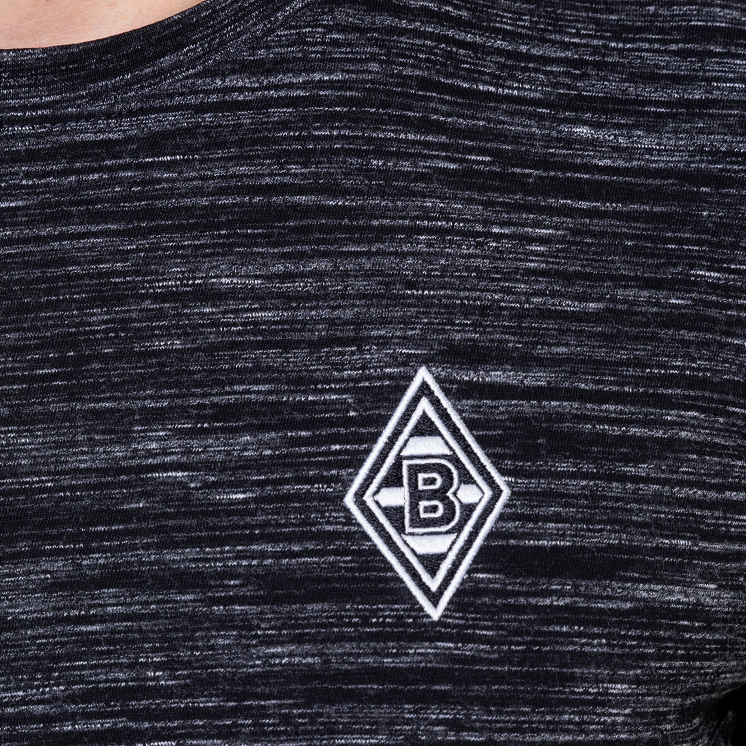 Schwarz-grau gestreiftes Shirt mit aufgesticktem Borussia Mönchengladbach Logo.