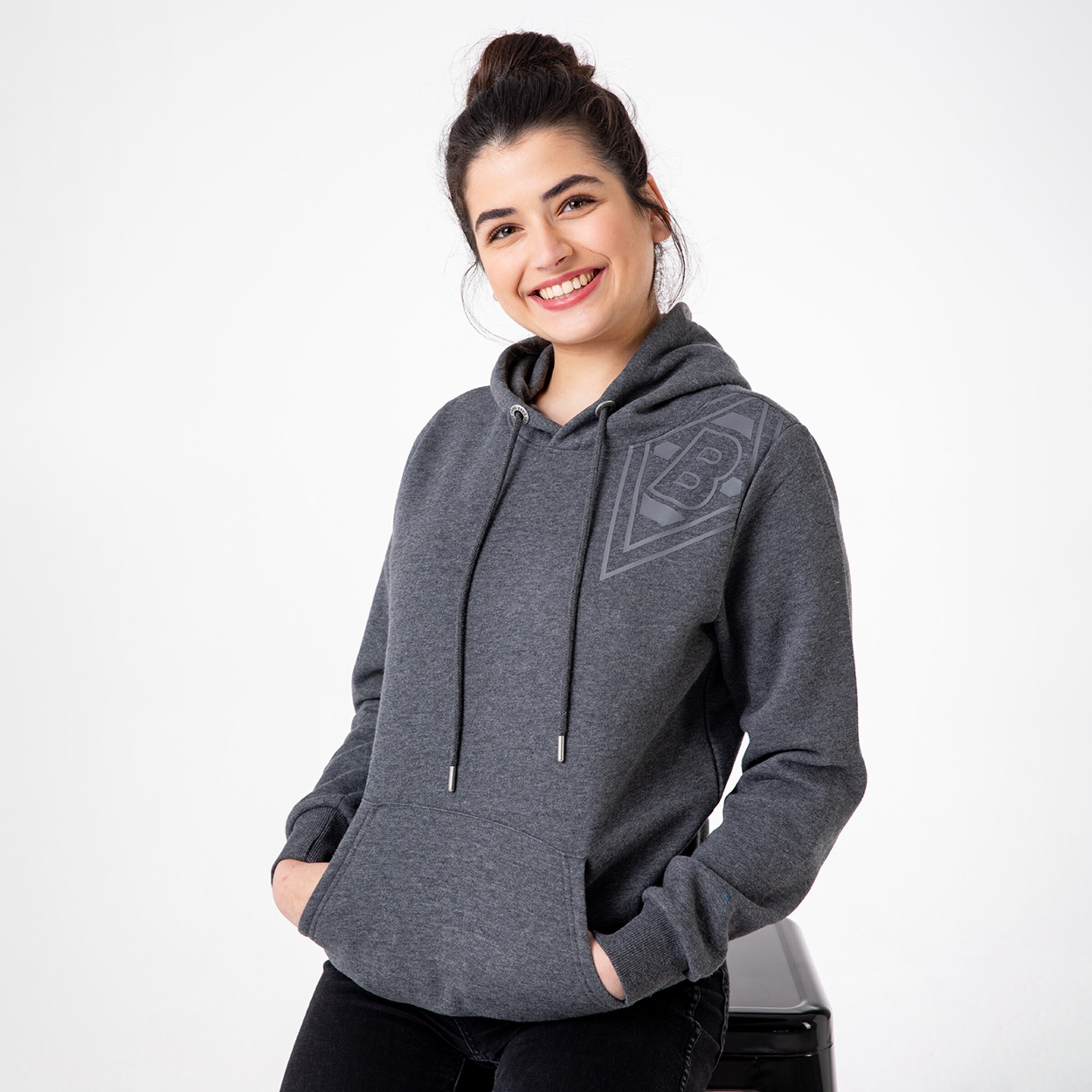 Junge Frau in grauem Hoodie mit Borussia Mönchengladbach-Logo.