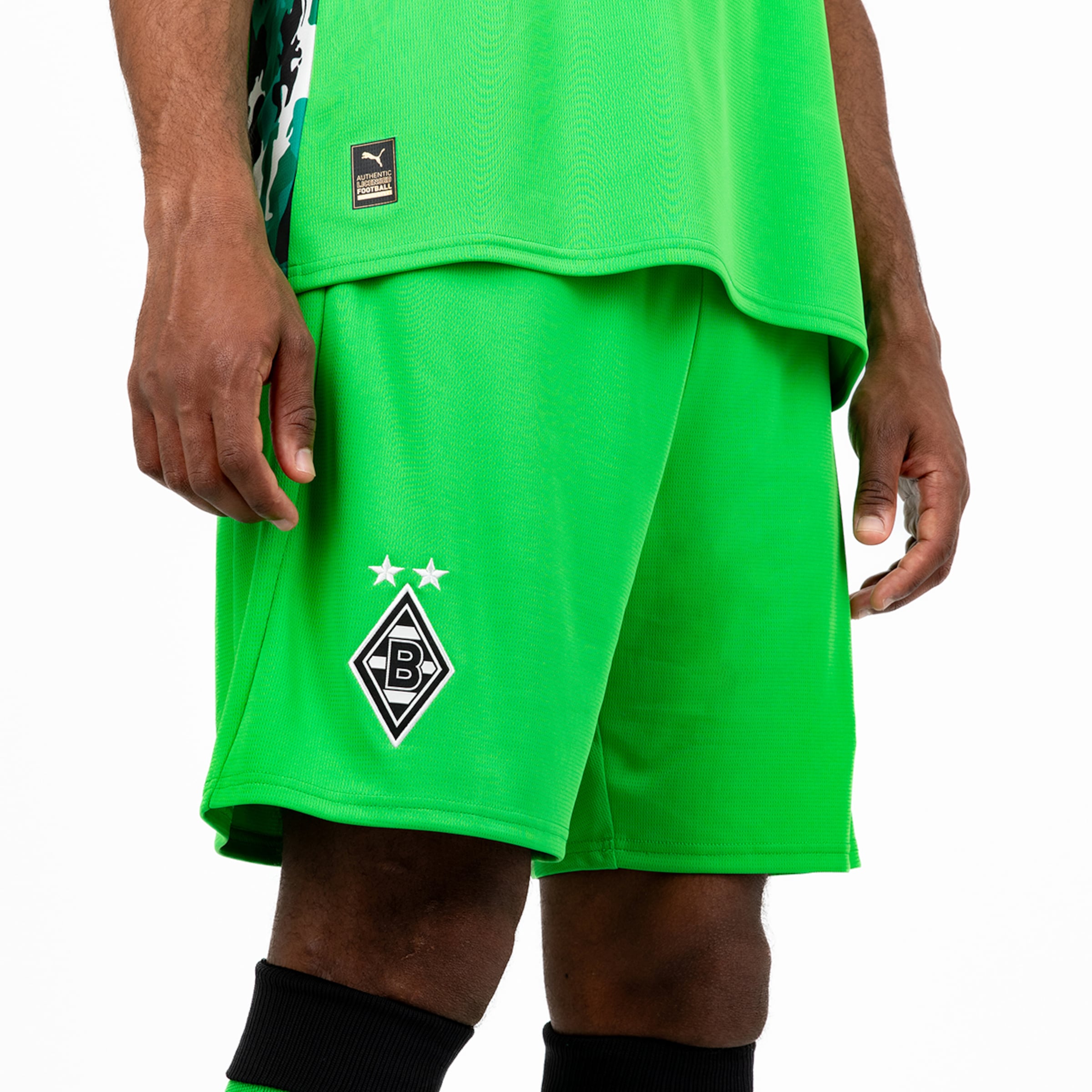 A player wearing a green Borussia Mönchengladbach jersey with shorts and socks.