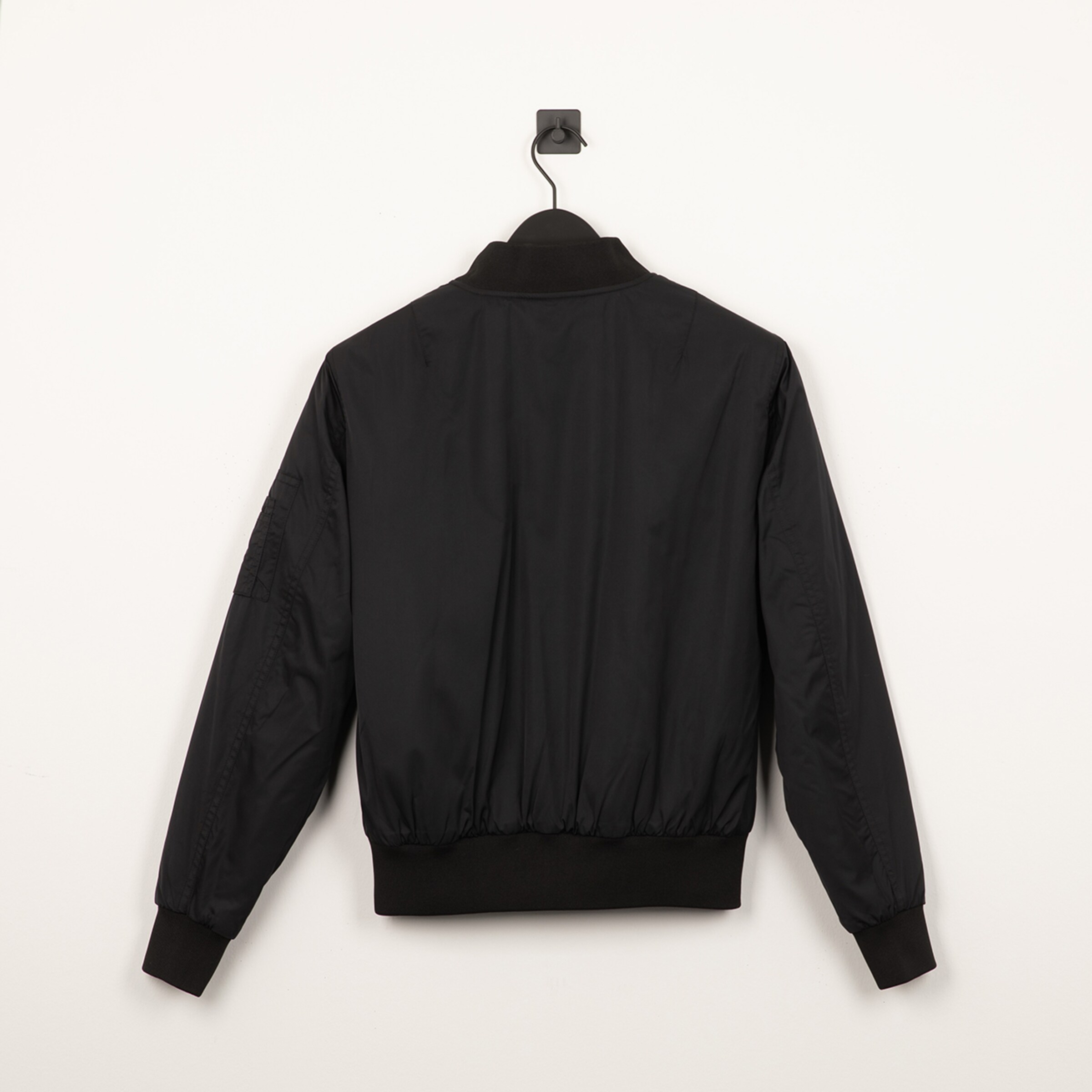 Black jacket with elastic hem back view.