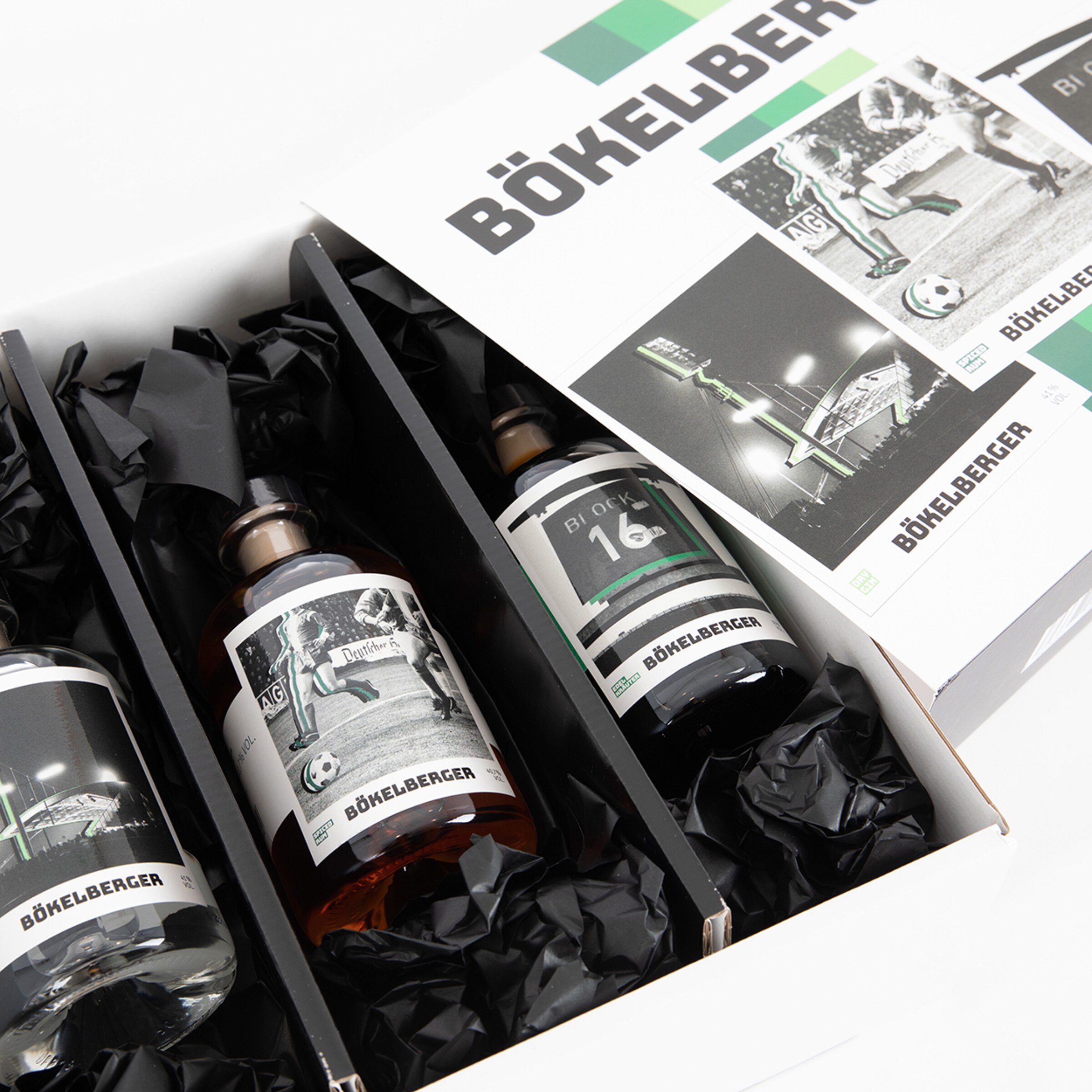 Geschenkbox mit drei Flaschen und etikettierten Abbildungen von Fußballmotiven.
