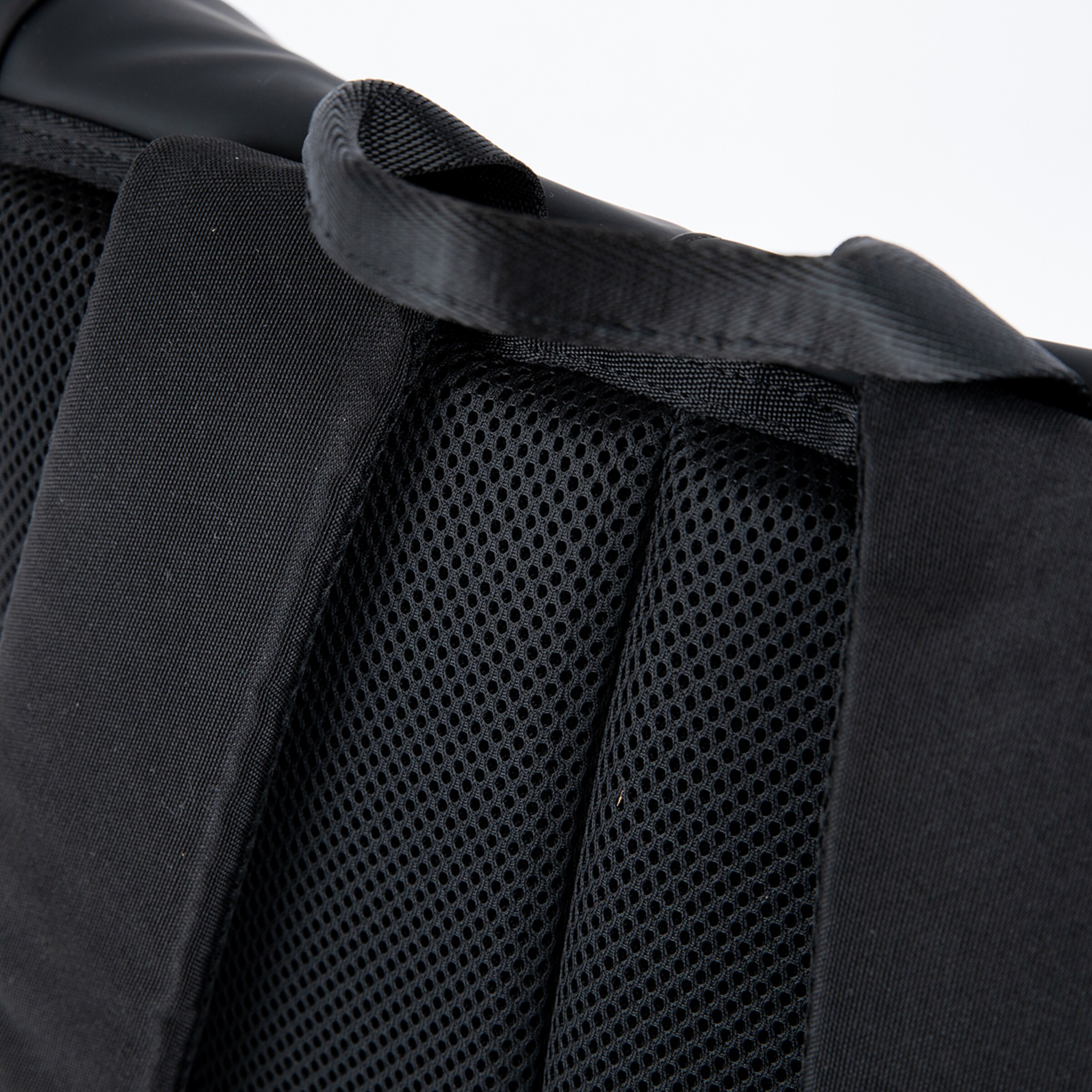 Detailaufnahme eines gepolsterten Rucksackmaterials mit Gitterstruktur und Tragegriff.