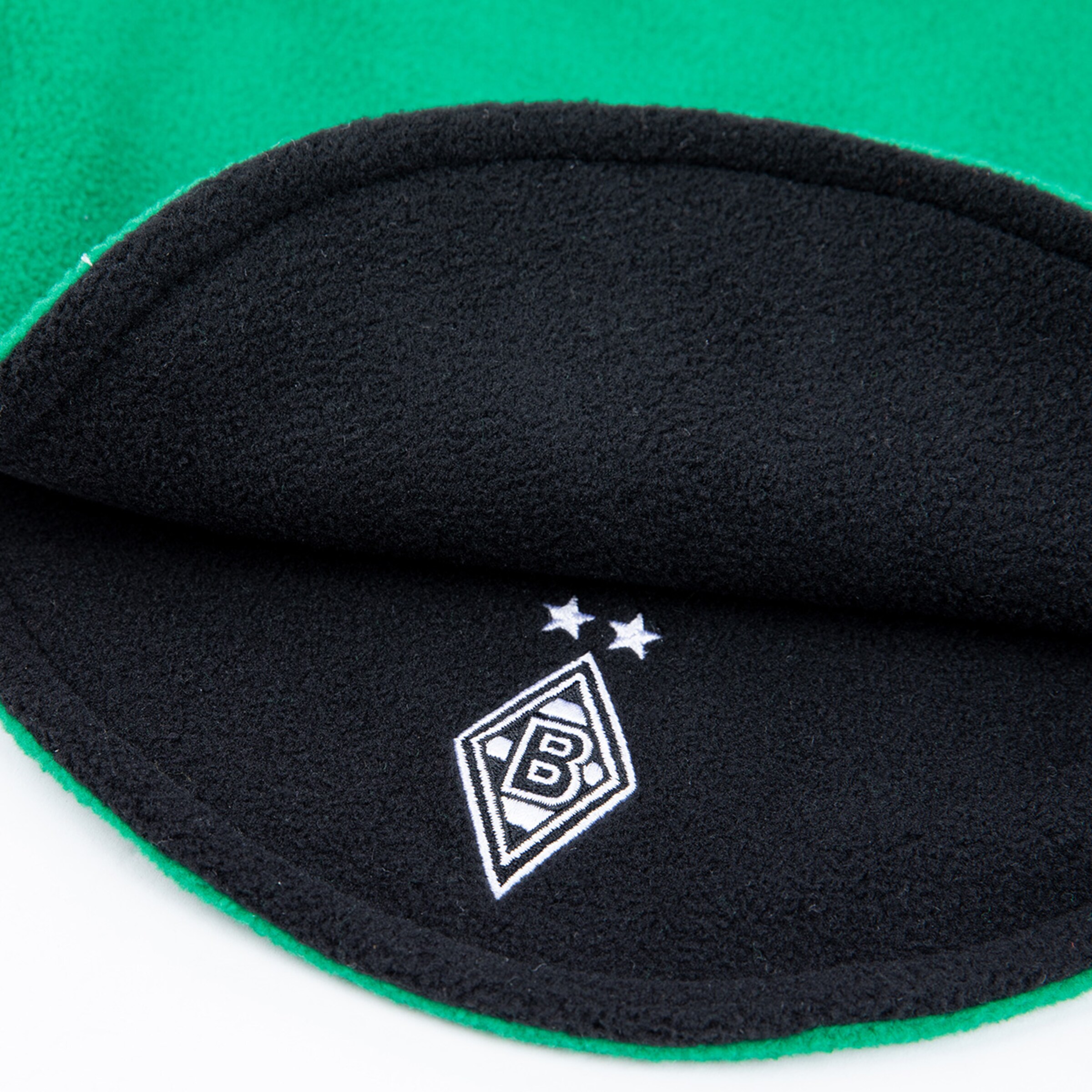 Schwarze Innenseite eines grünen Kleidungsstücks mit dem Borussia Mönchengladbach-Logo und zwei Sternen.