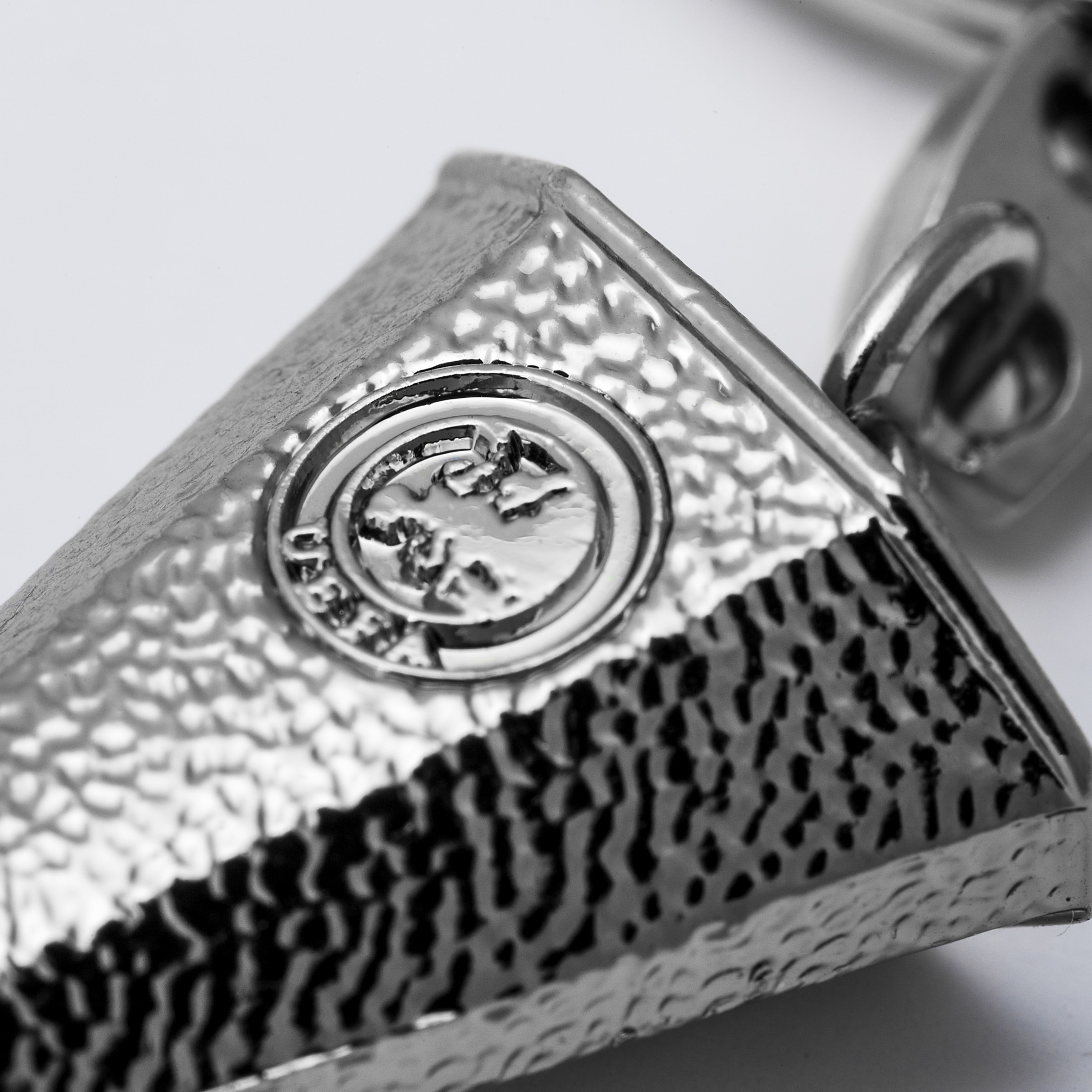 Extreme close-up of a silver trophy with a hammered texture and an embossed UEFA logo featuring a world map.