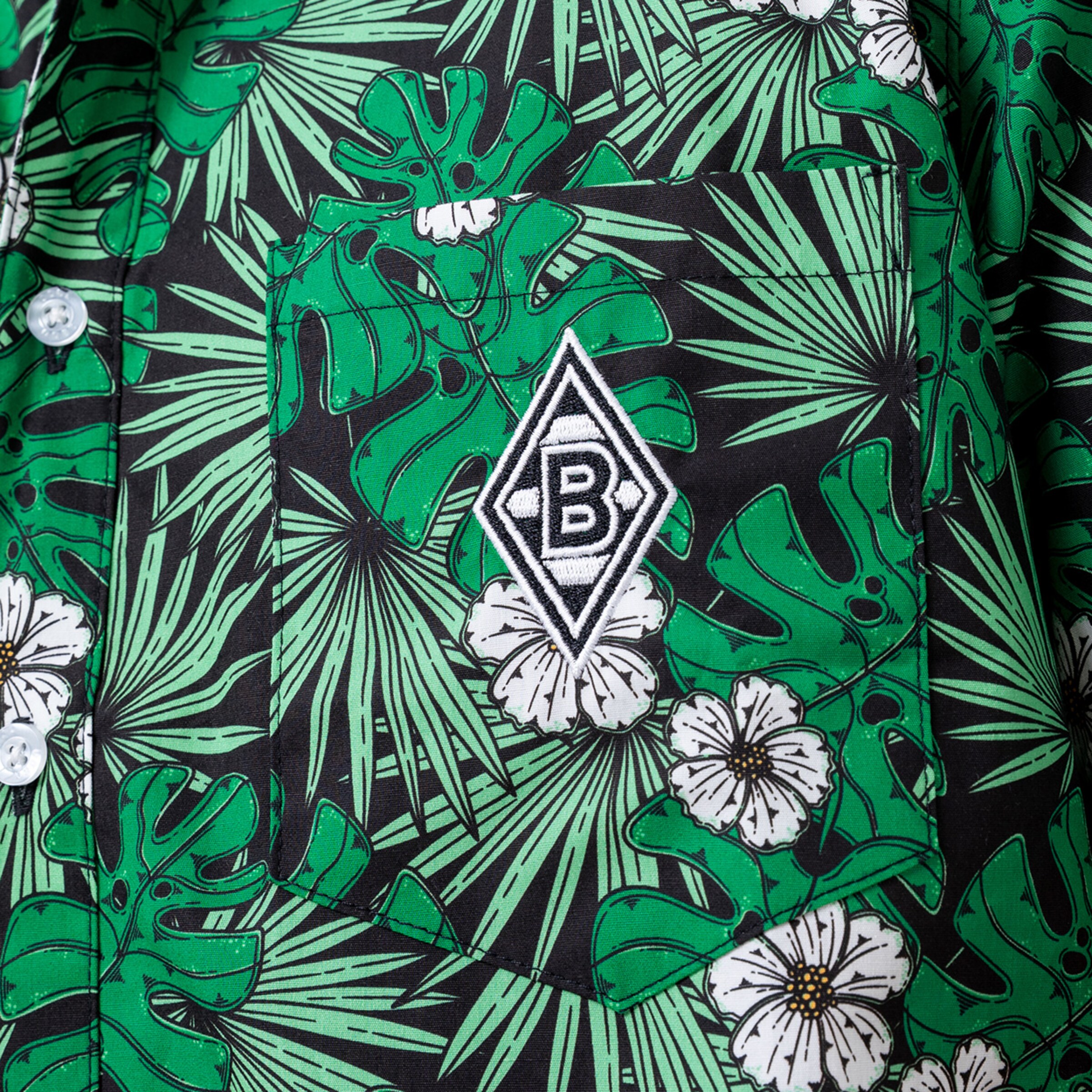 Vorderansicht eines Hemdes mit grünem Blattmuster und Blumen auf der Brust ist das Borussia Mönchengladbach-Logo.