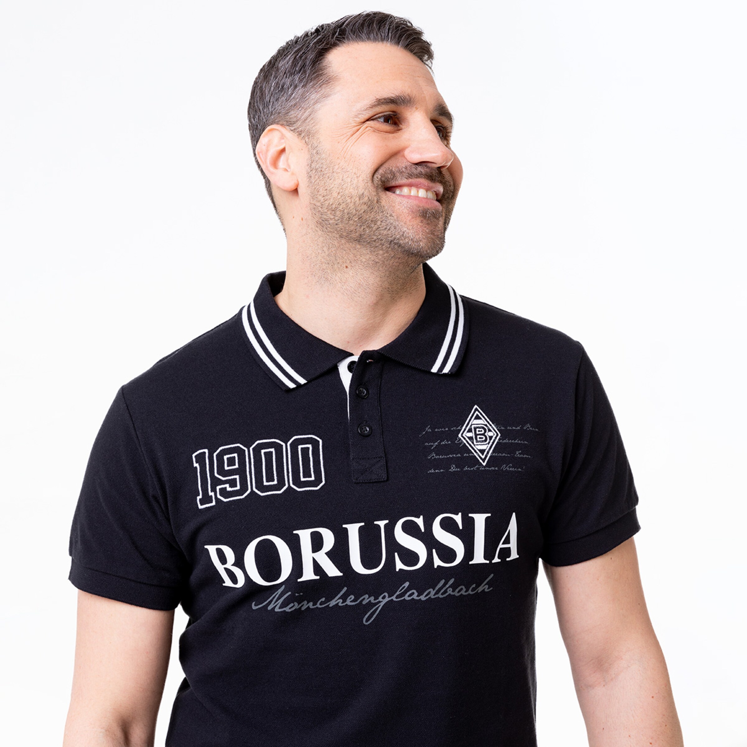 Mann in schwarzem Polo-Shirt mit Aufdruck BORUSSIA Mönchengladbach und Jahr 1900