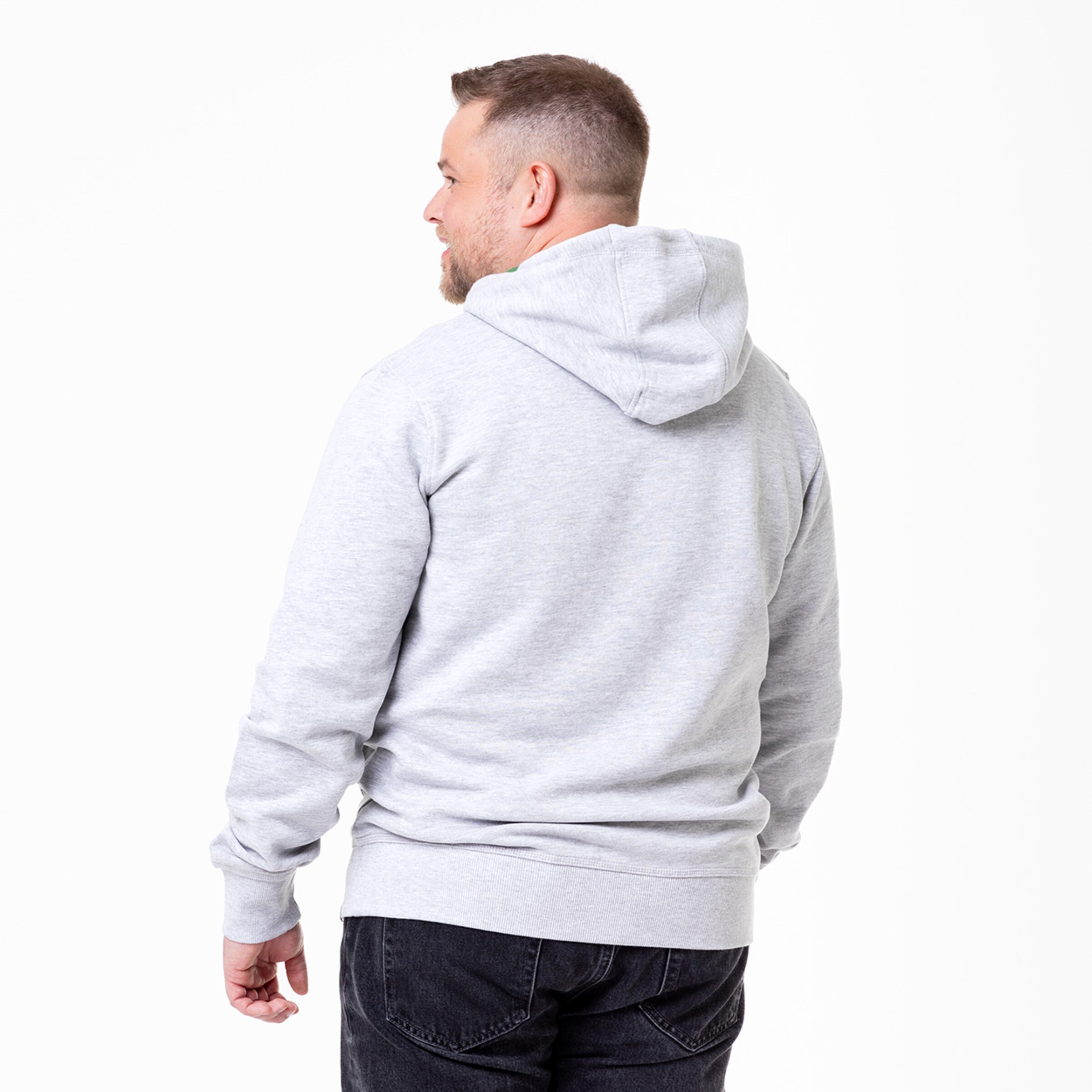 Ein Mann trägt einen grauen Kapuzenpulli von hinten gesehen.