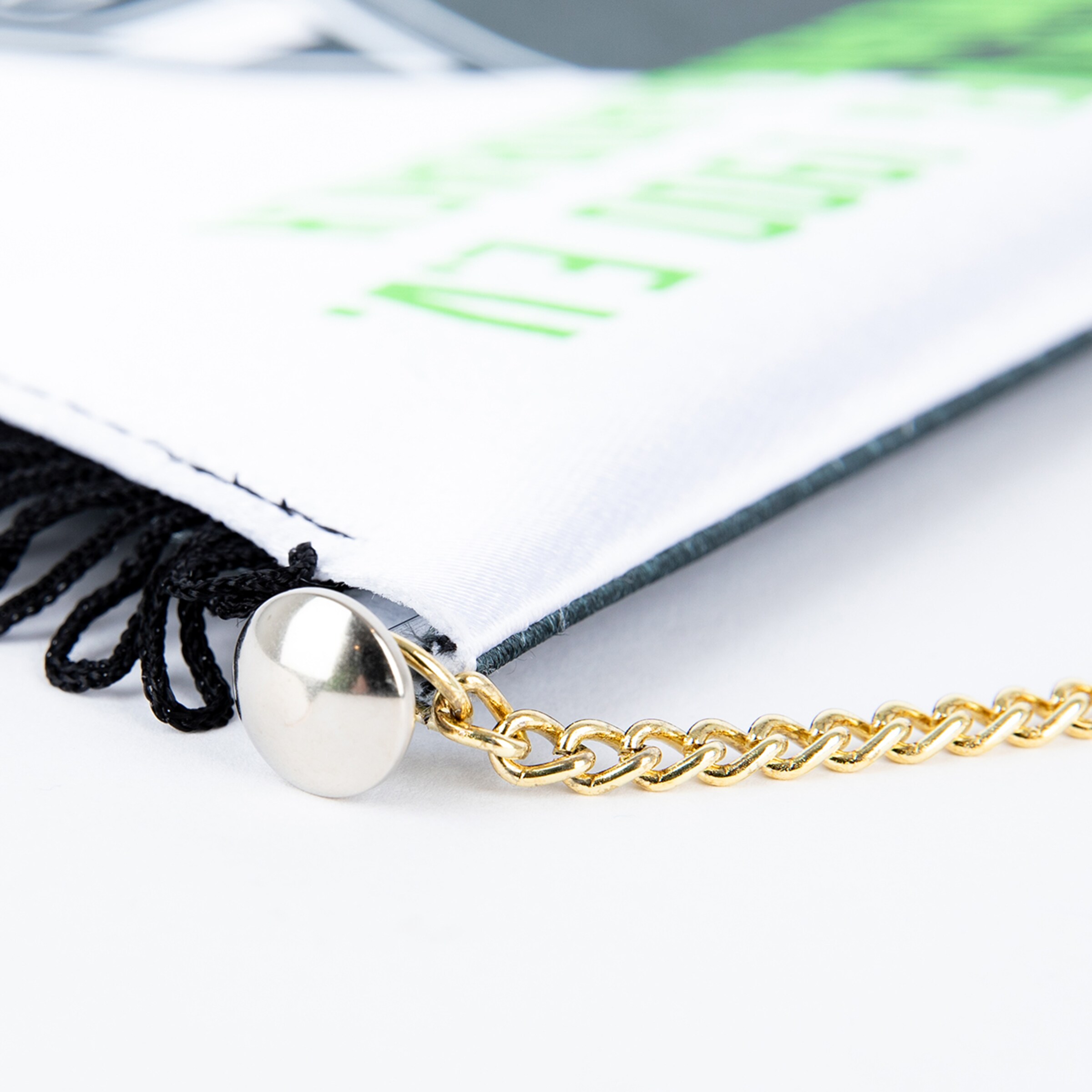 Detailaufnahme einer Fahne mit schwarzem Seil und goldener Kette.