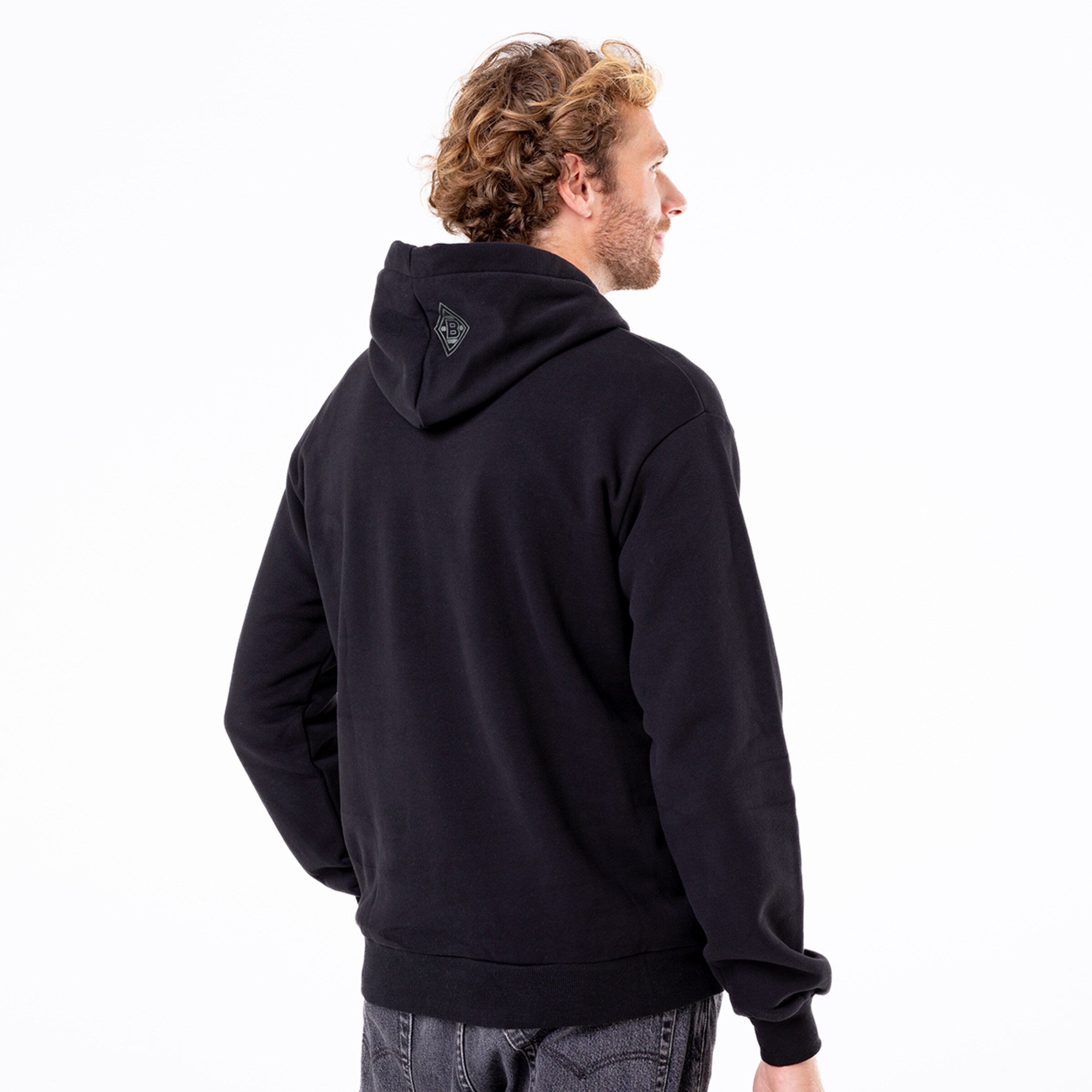 Hinteransicht eines Mannes in schwarzem Kapuzenpullover.