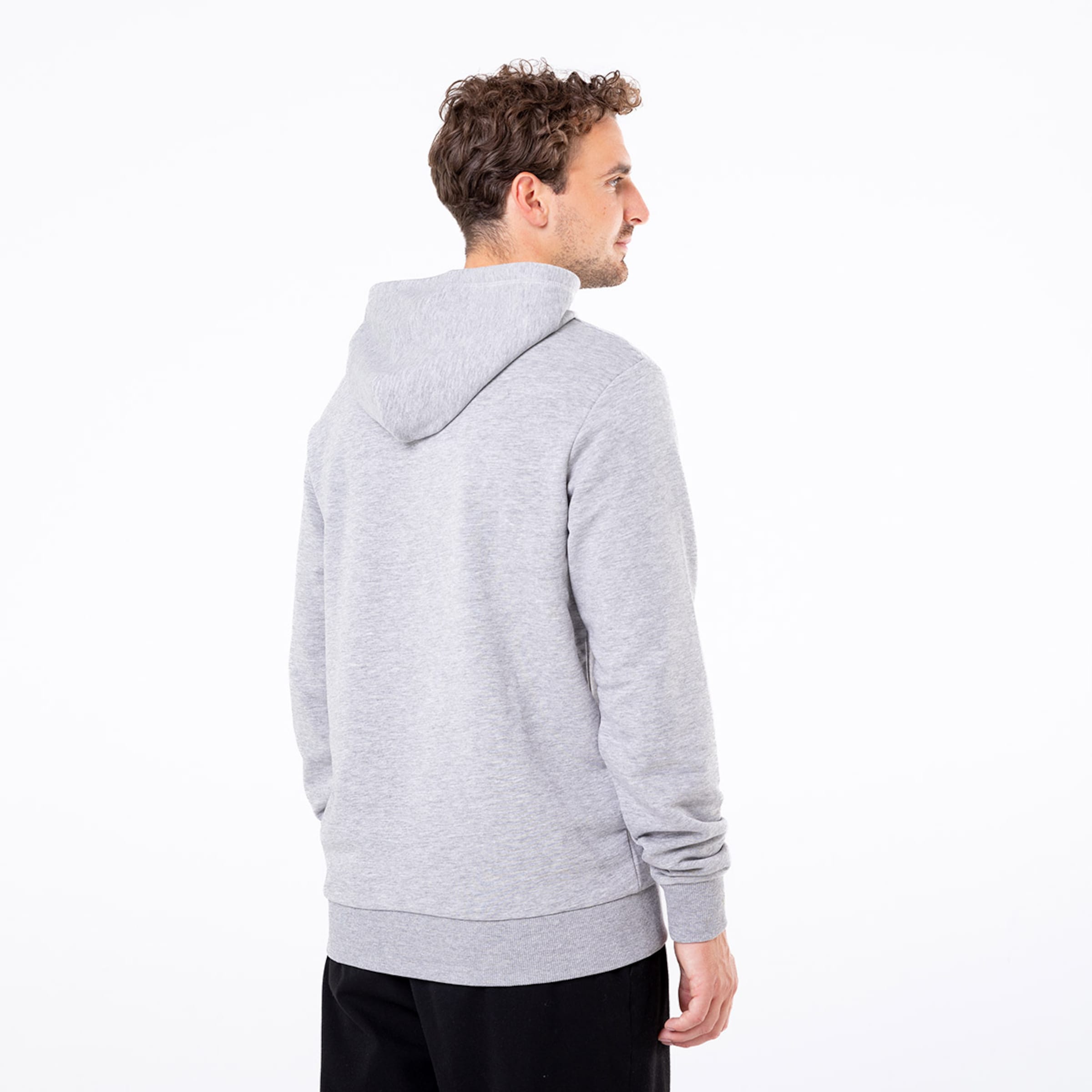 Mann mit grauem Hoodie von hinten gesehen. Friseur ist etwas lockig.