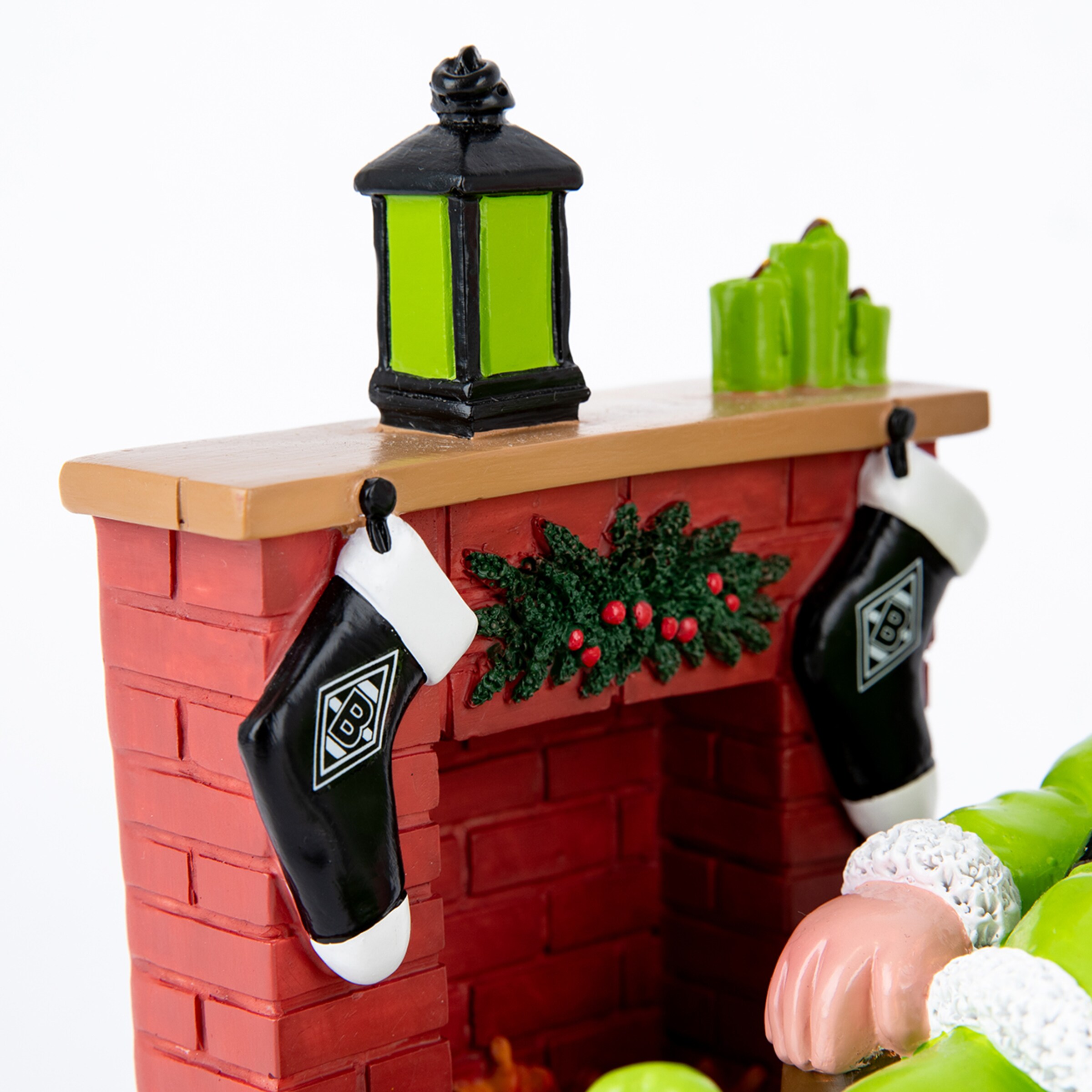 Detail eines weihnachtlichen Kamins mit Borussia Mönchengladbach Strümpfen, einer grünen Laterne und einem Kranz auf weißem Grund.