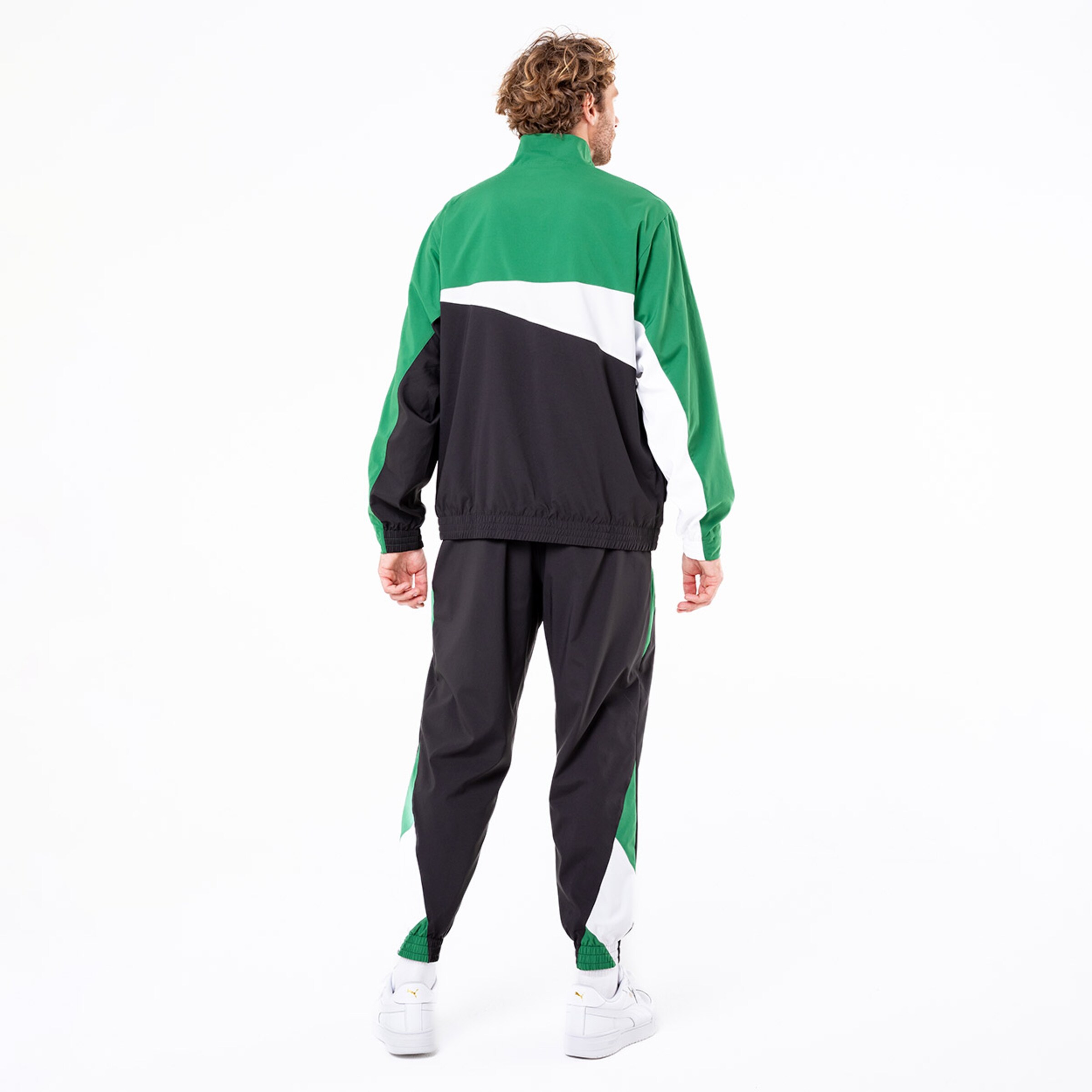 Mann mit grüner schwarzer und weißer Sportjacke die von hinten sichtbar ist.