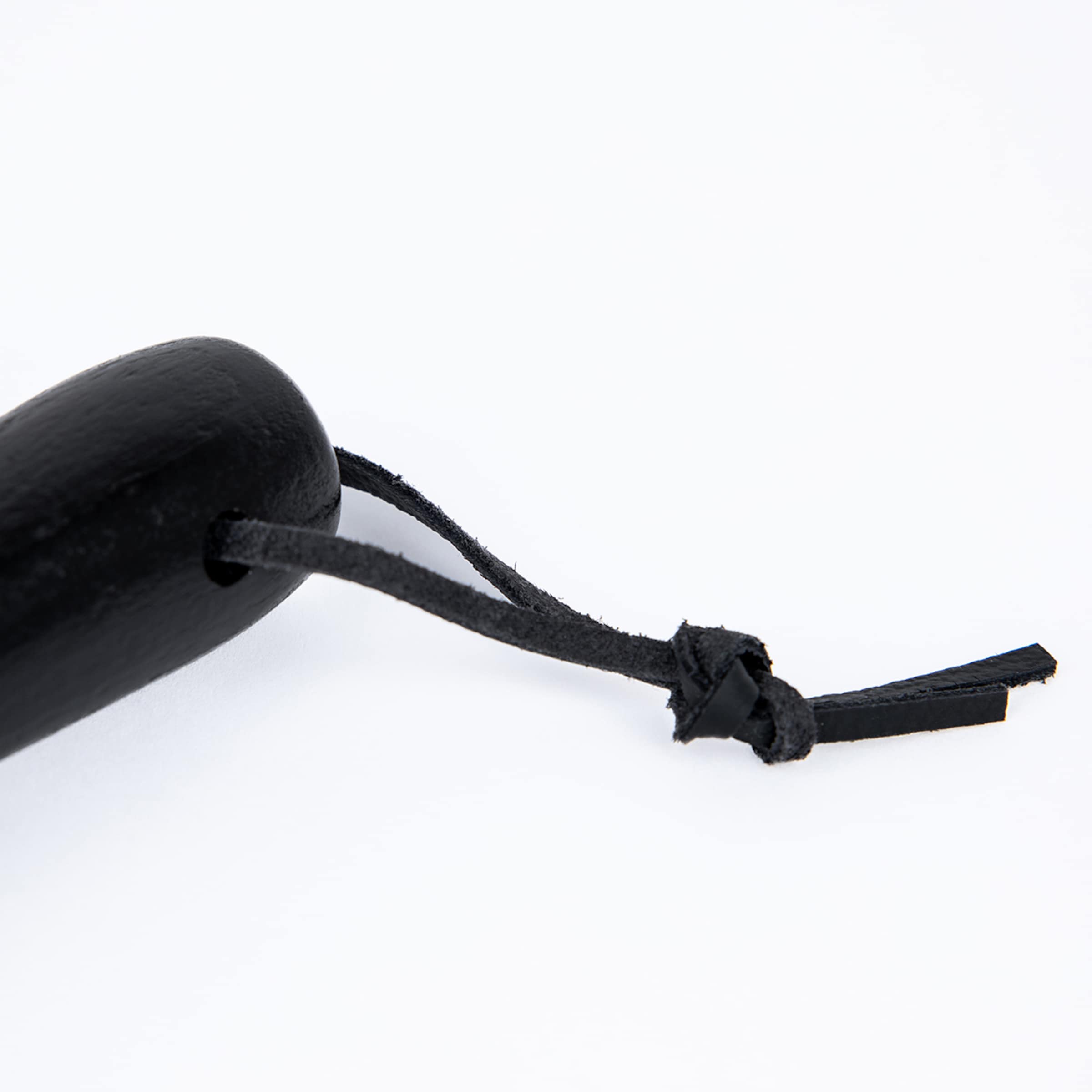 Schwarzer Holzgriff mit einer Lederschlaufe, die durch eine Bohrung geführt und verknotet ist, vor weißem Hintergrund.