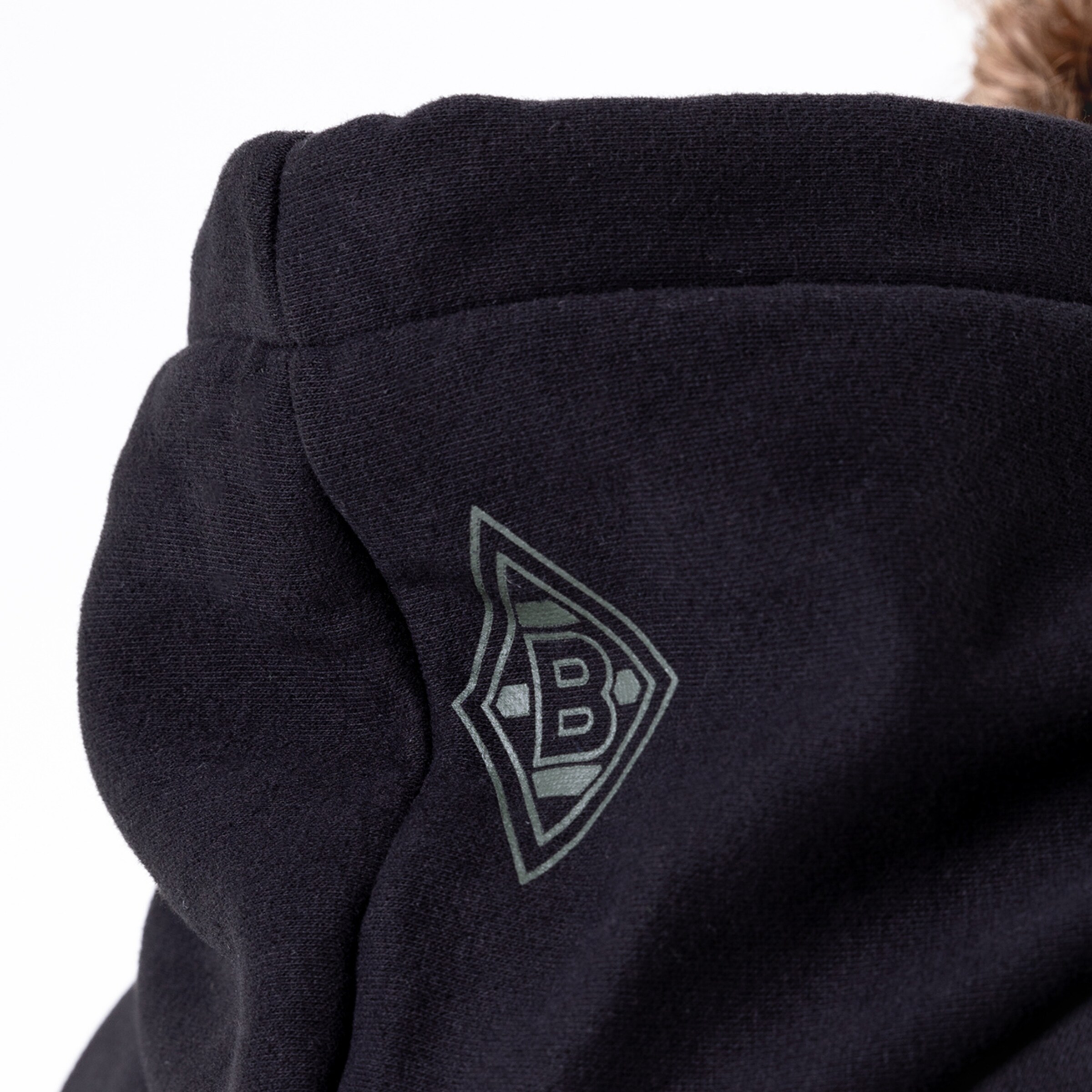 Detailansicht eines schwarzen Hoodies mit grünem Borussia Mönchengladbach-Logo auf der Kapuze.