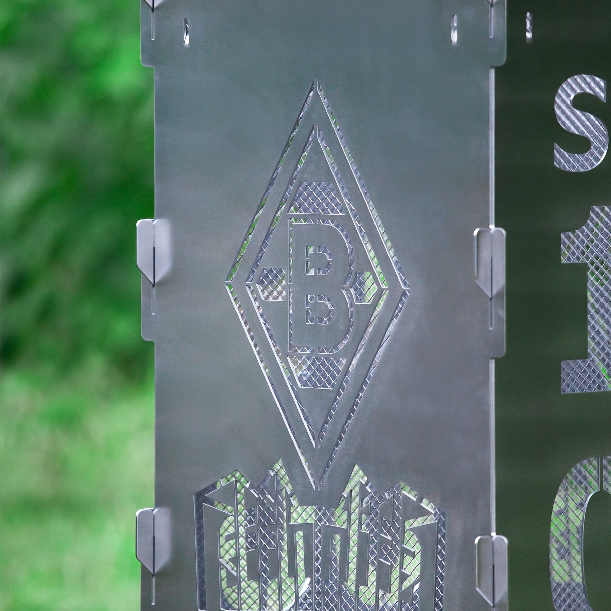 Auf einer Metalloberfläche ist das Borussia Mönchengladbach-Logo und die Zahl 1900 eingraviert.