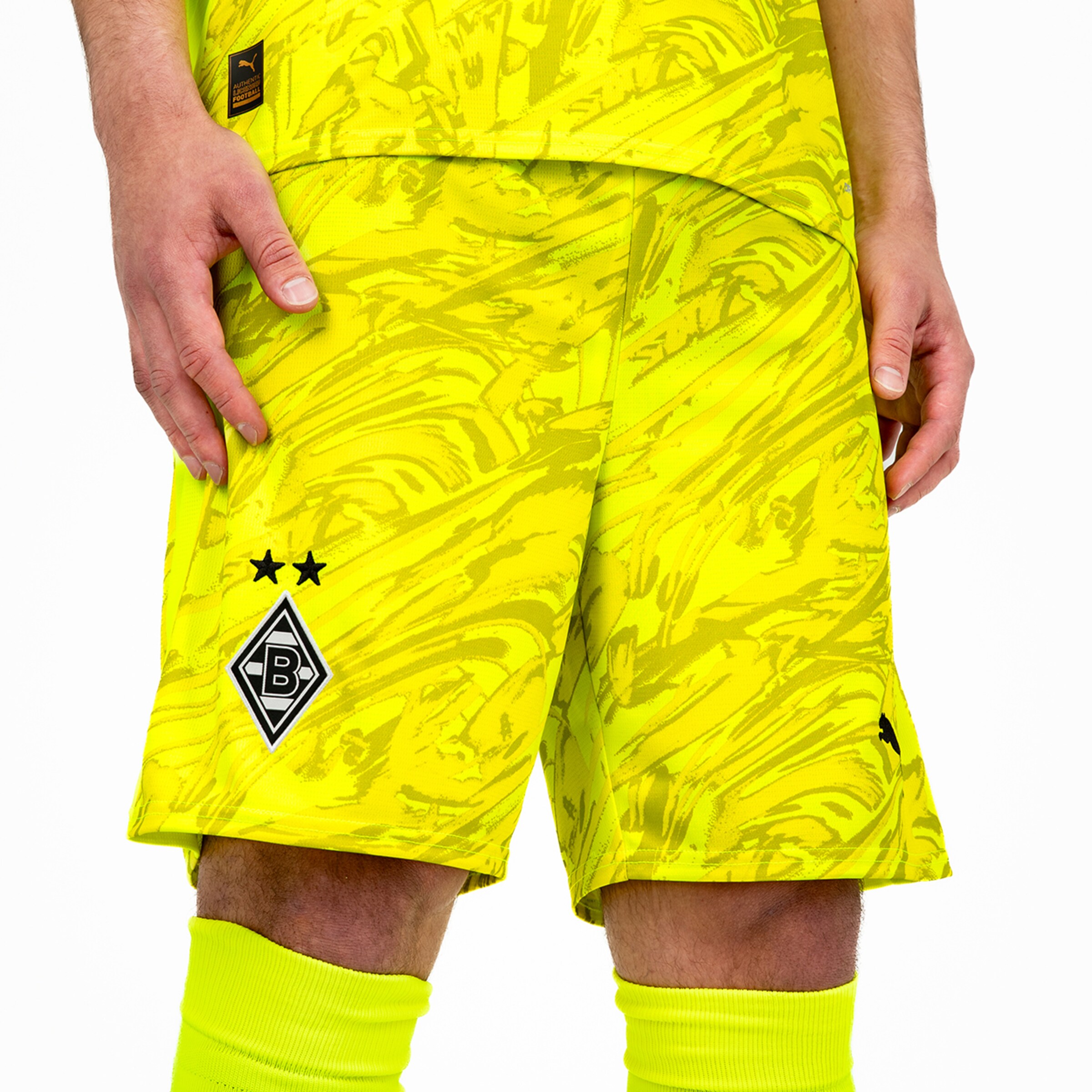 Bright patterned soccer shorts in neon color featuring Borussia Mönchengladbachs logo.