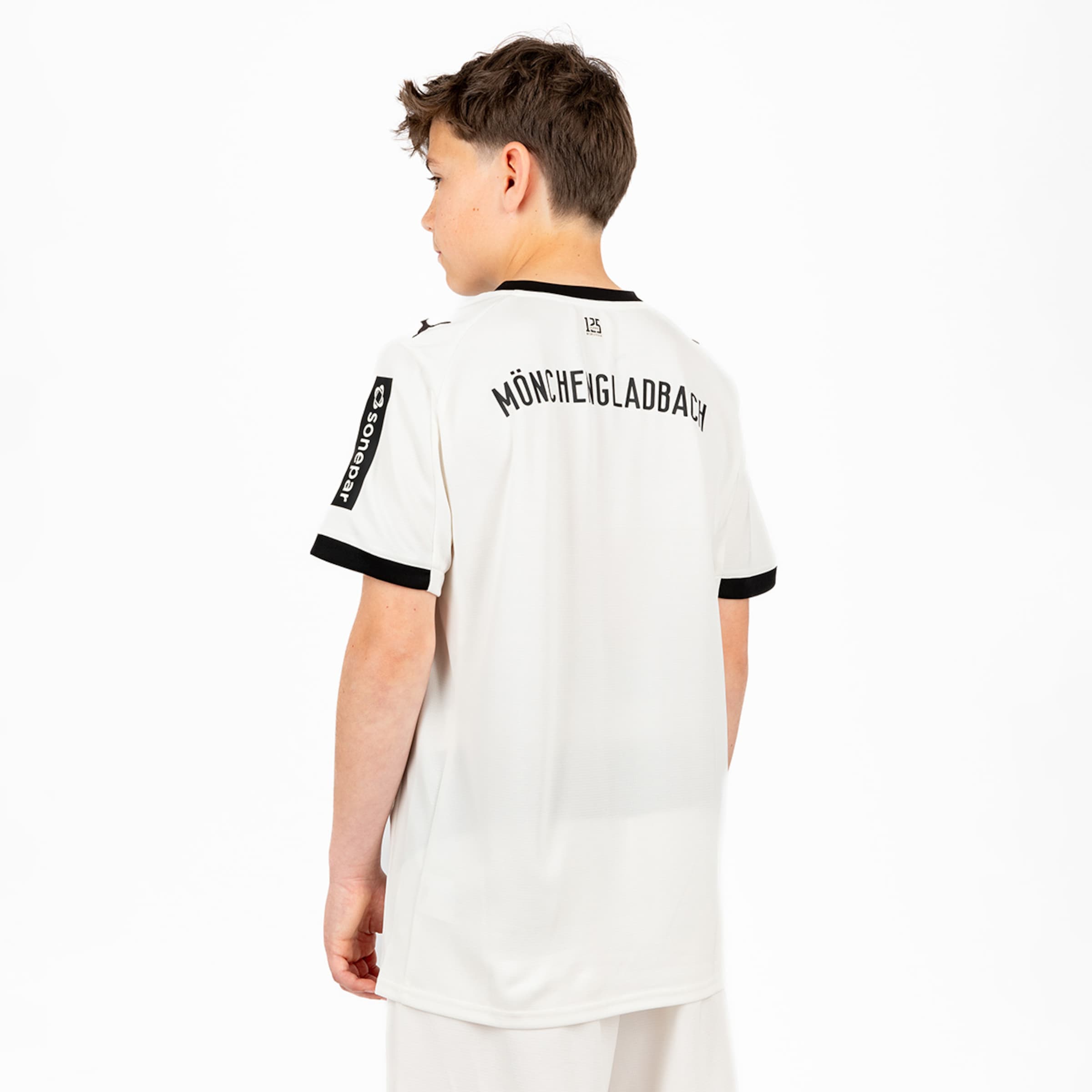 Junge trägt das Fußballtrikot von Borussia Mönchengladbach mit Mönchengladbach auf dem Rücken.