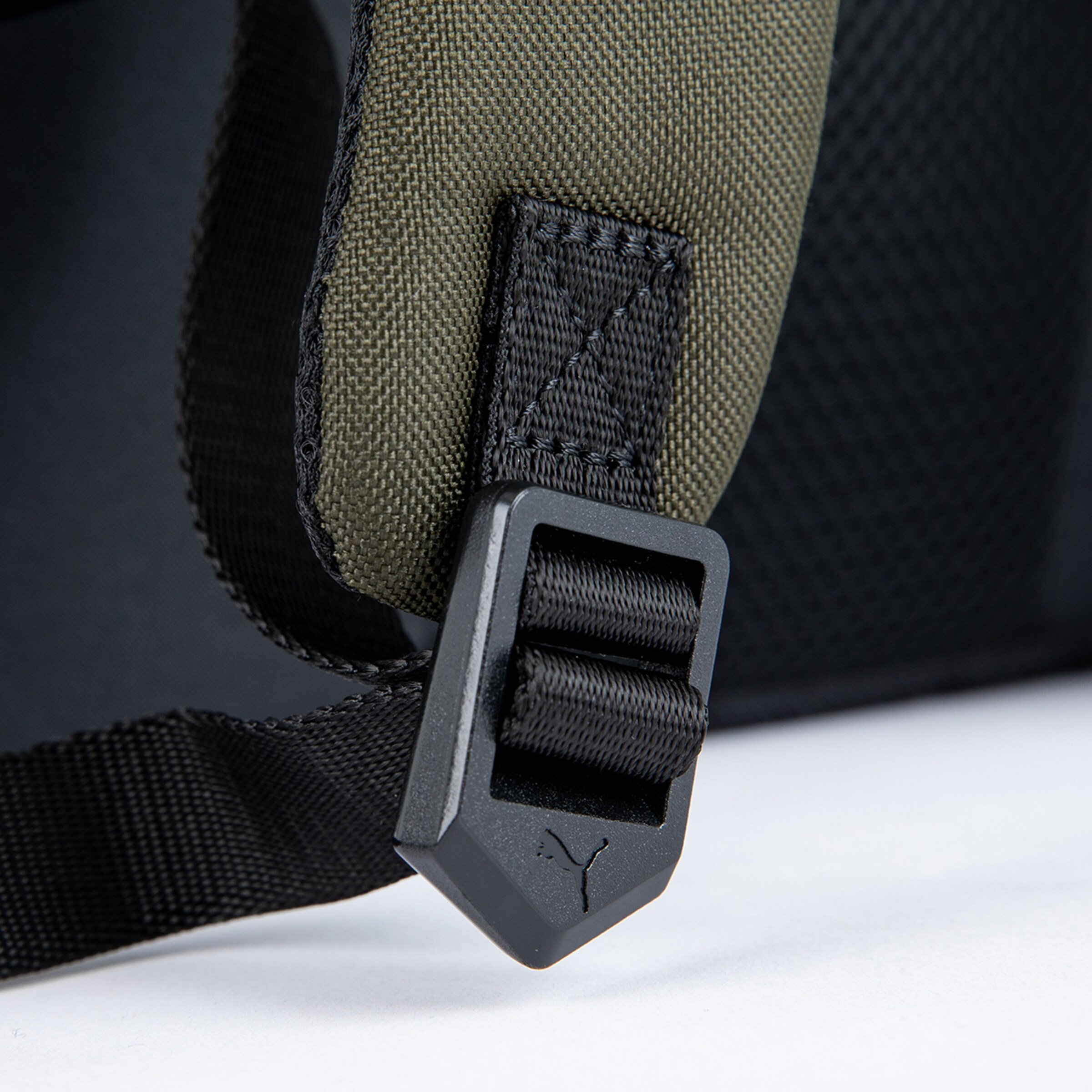 Detailansicht eines schwarzen Riemens mit einem Kunststoffverschluss featuren das Puma-Logo.