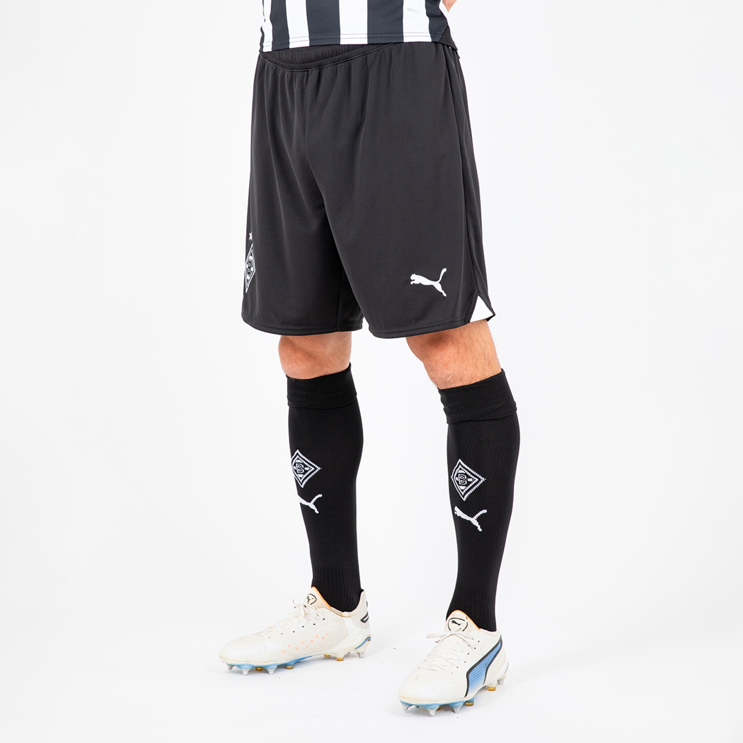 Schwarze Fußballshorts und schwarze Stulpen mit Puma-Logo und Borussia Mönchengladbach-Emblem.