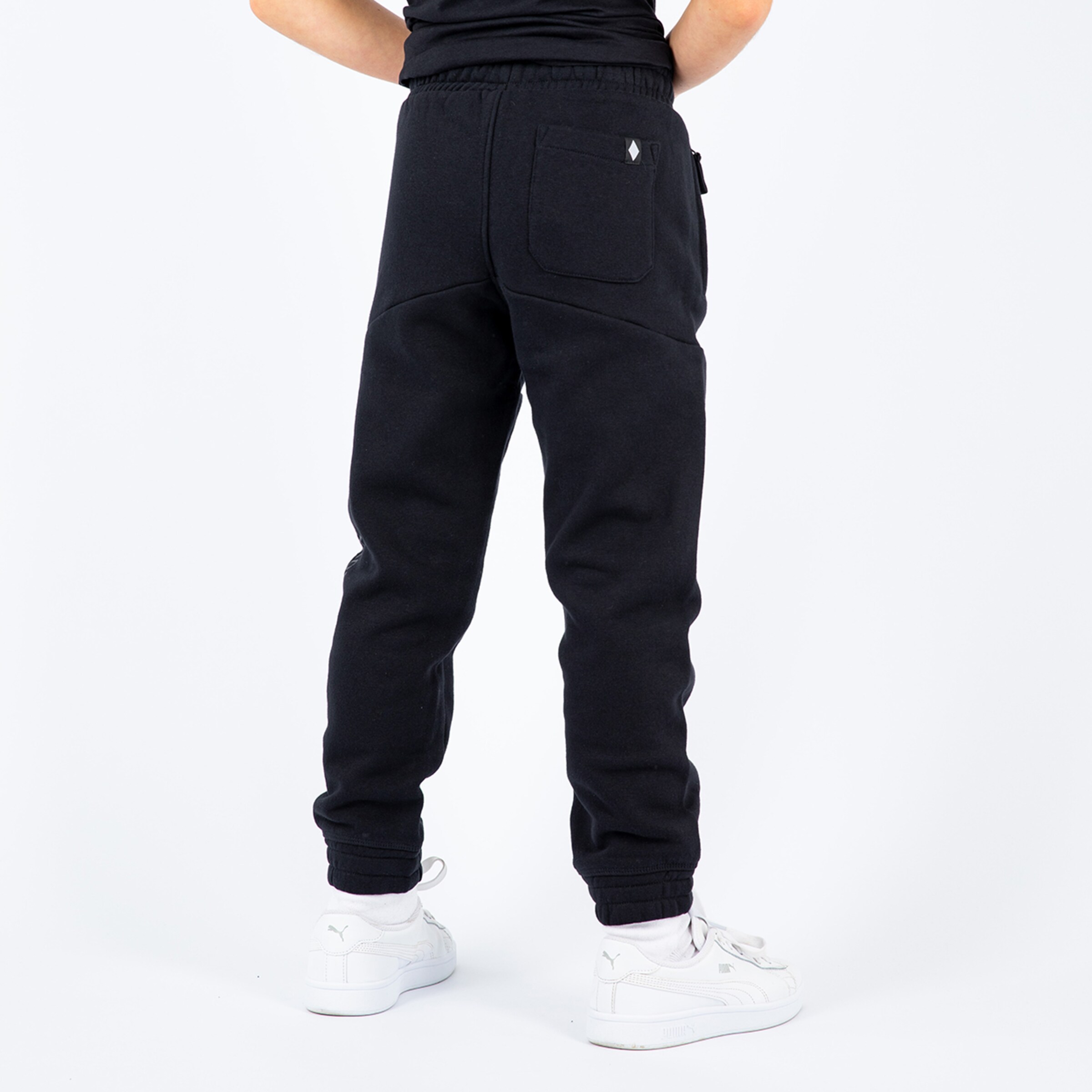 Schwarze Jogginghose mit elastischem Bund von hinten sichtbar.