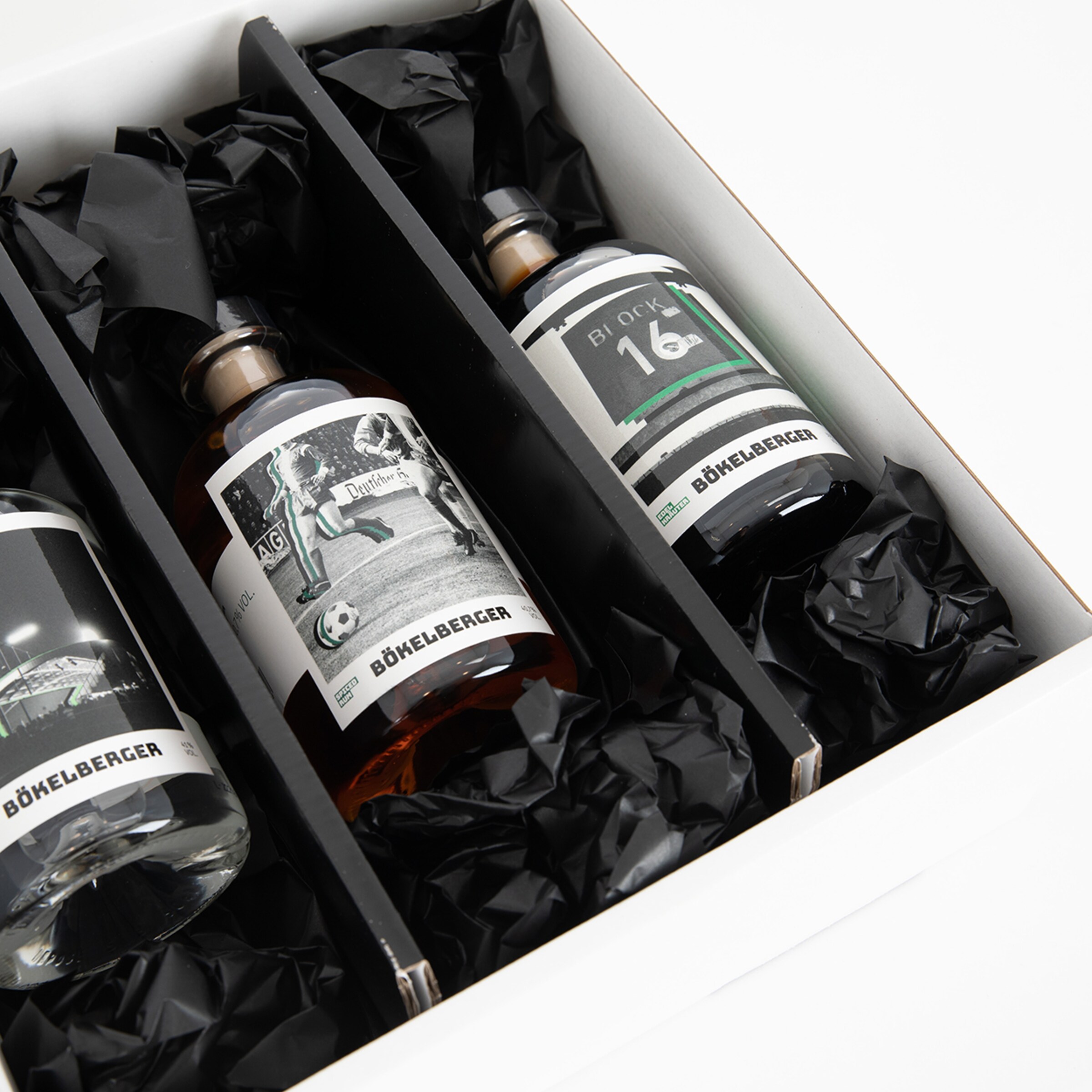 Drei Flaschen Böhleberger Spirituosen in einer Geschenkverpackung mit schwarzem Füllmaterial.