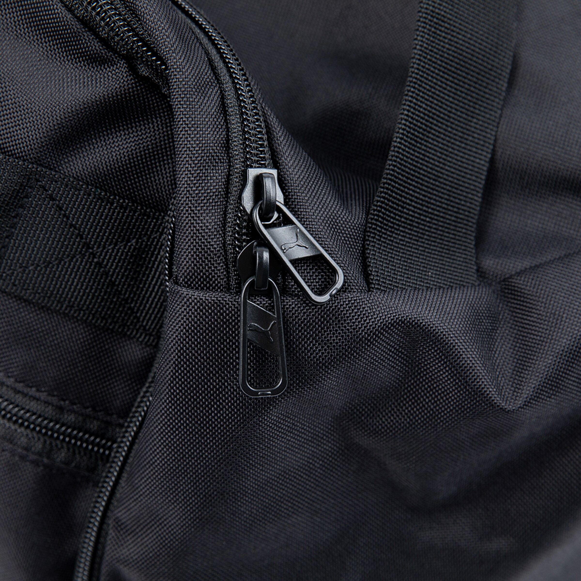 Schwarze Puma-Tasche mit Reißverschluss und Label.