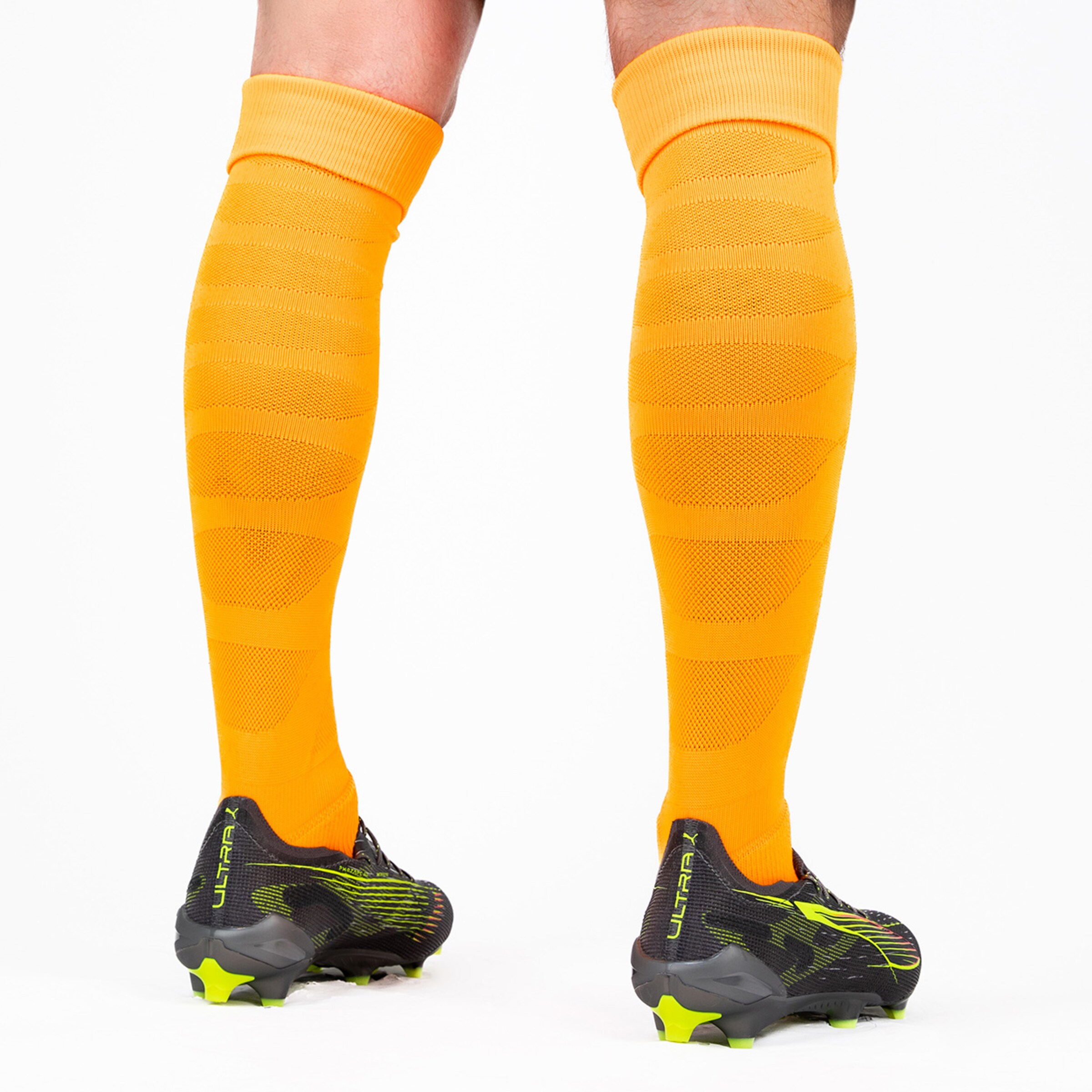 Schwarze Fußballschuhe mit neongelben Akzenten und orangenen Stutzen.