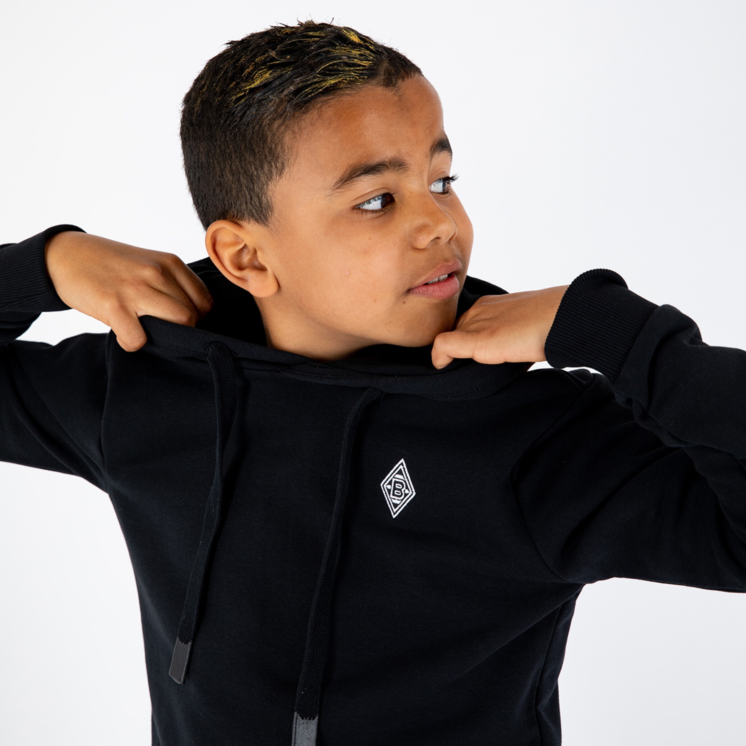 Junge trägt einen schwarzen Hoodie mit Borussia Mönchengladbach-Logo und schaut zur Seite.
