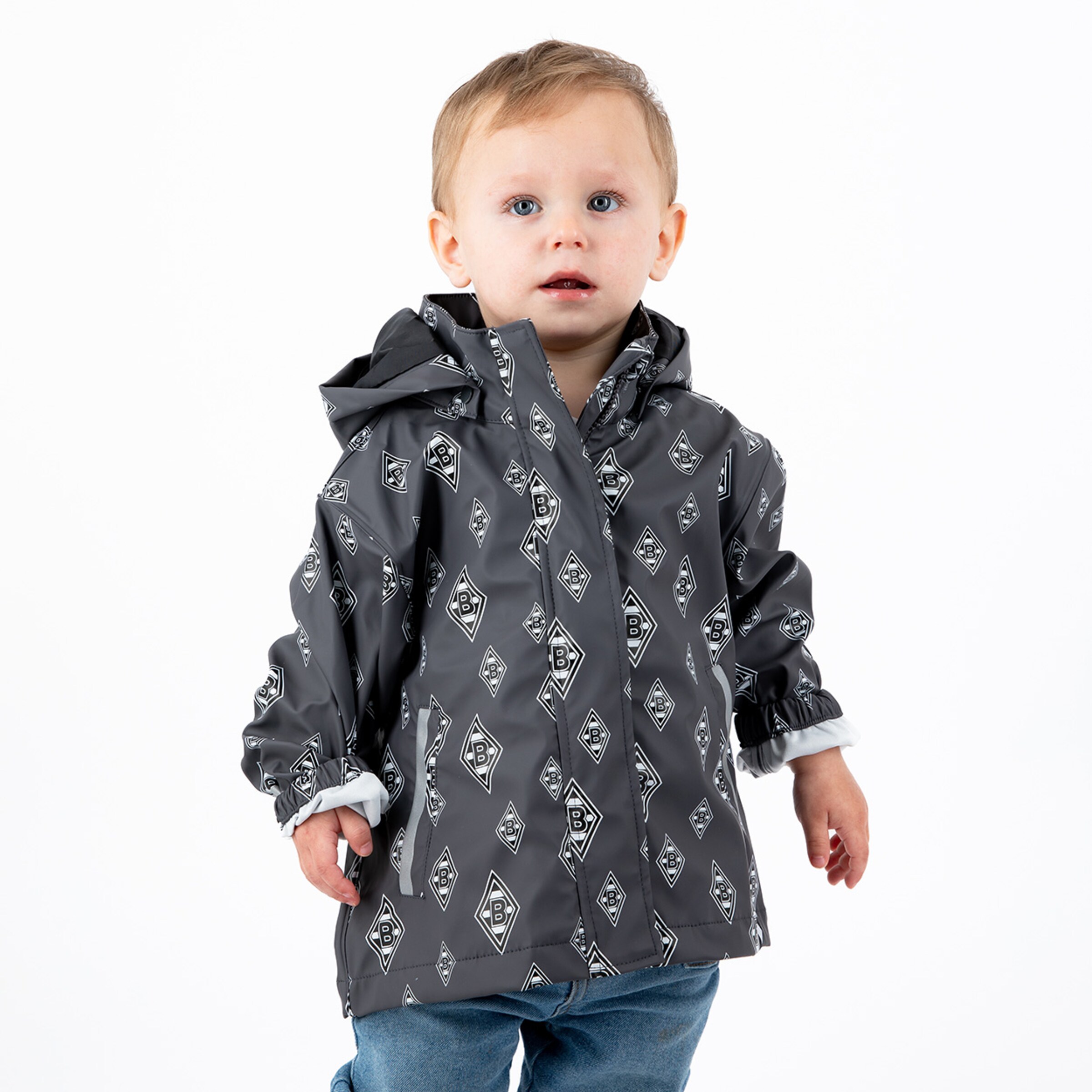 Kleines Kind in grauem Regenmantel mit Borussia Mönchengladbach-Logo