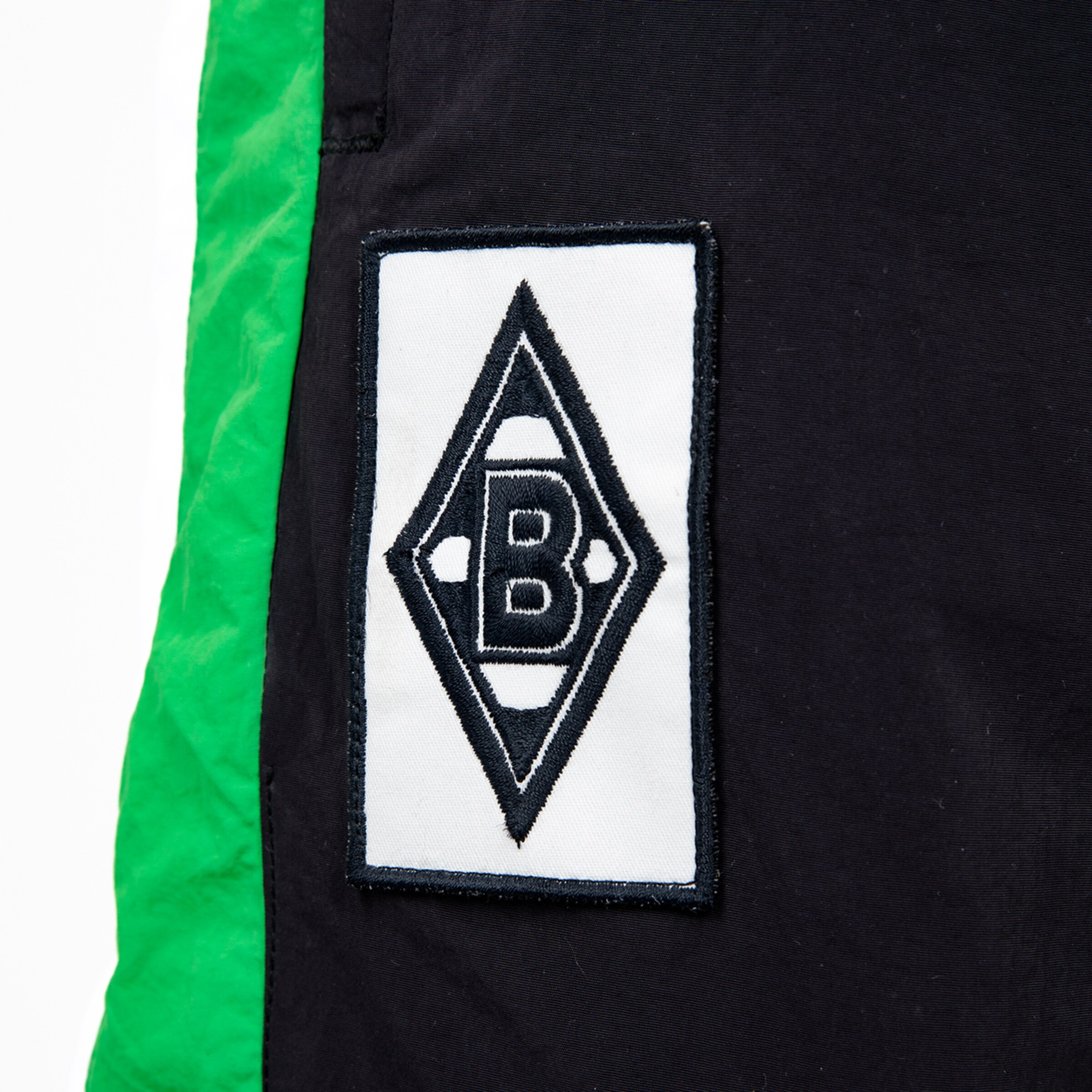 Aufnäher des Borussia Mönchengladbach Logos auf schwarzem Stoff mit grünen Akzenten.