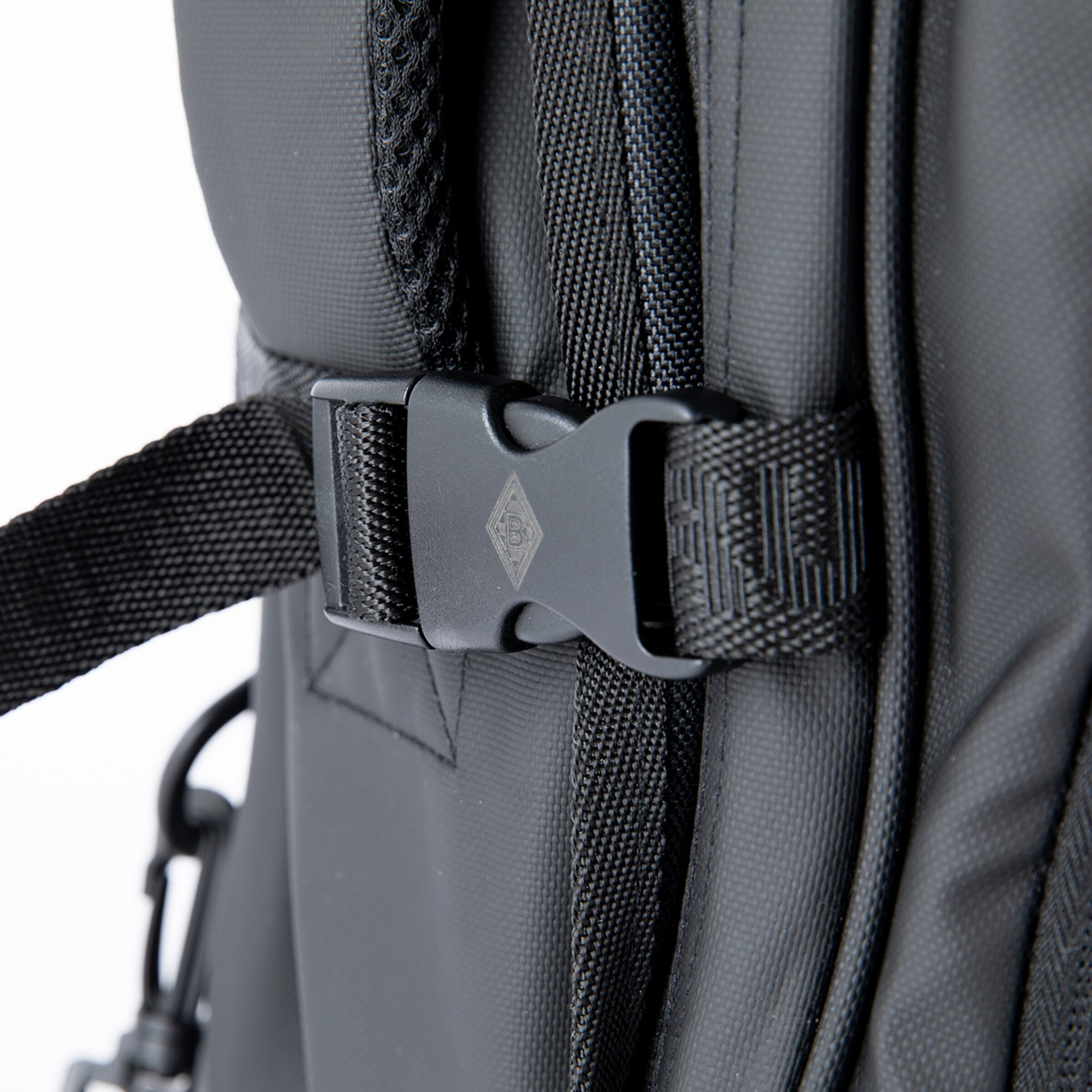 Schwarzer Rucksack mit einer Kunststoffschnalle an einem Trageriemen.