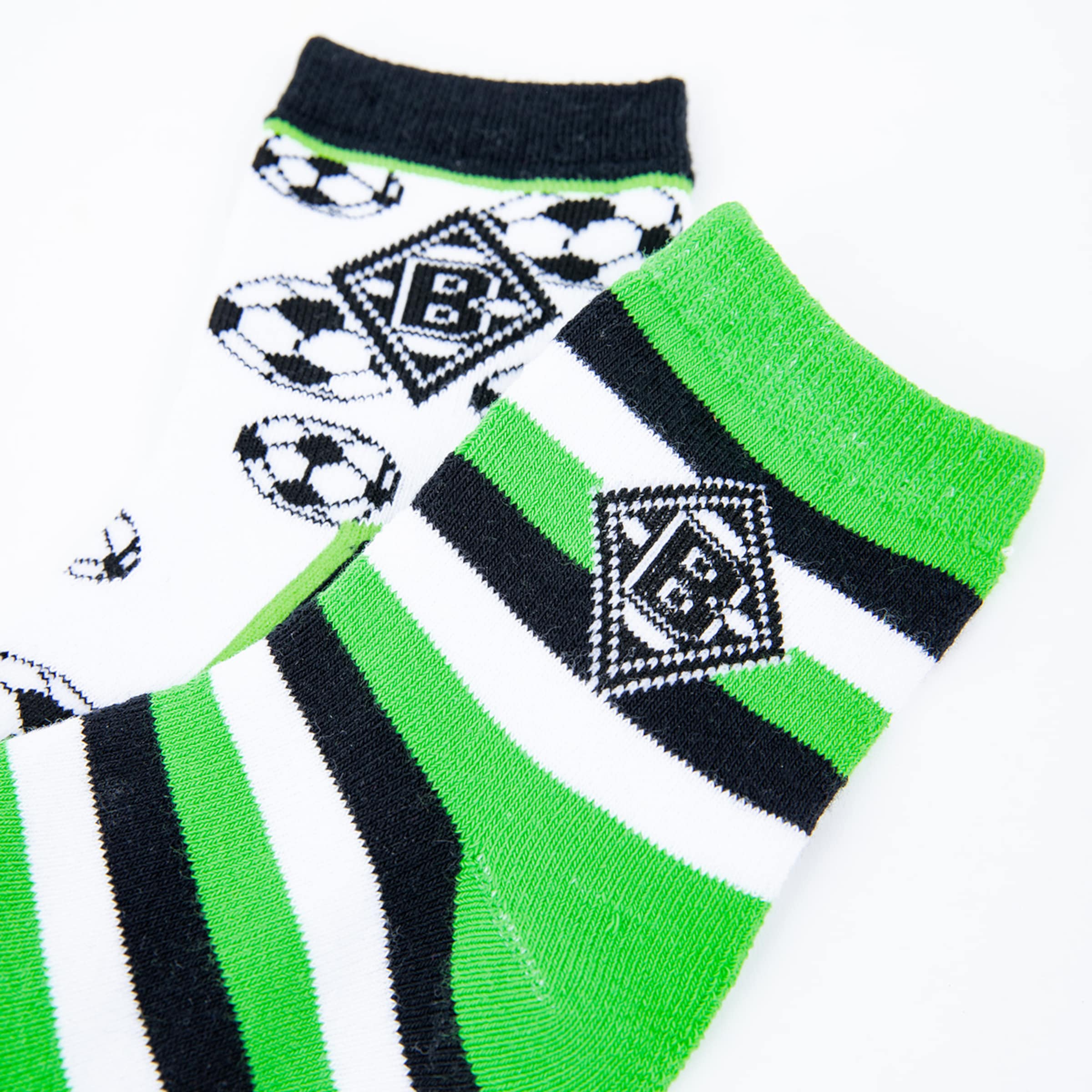 Short socks in black and white with soccer motifs and green striped socks featuring Borussia Mönchengladbach logo.