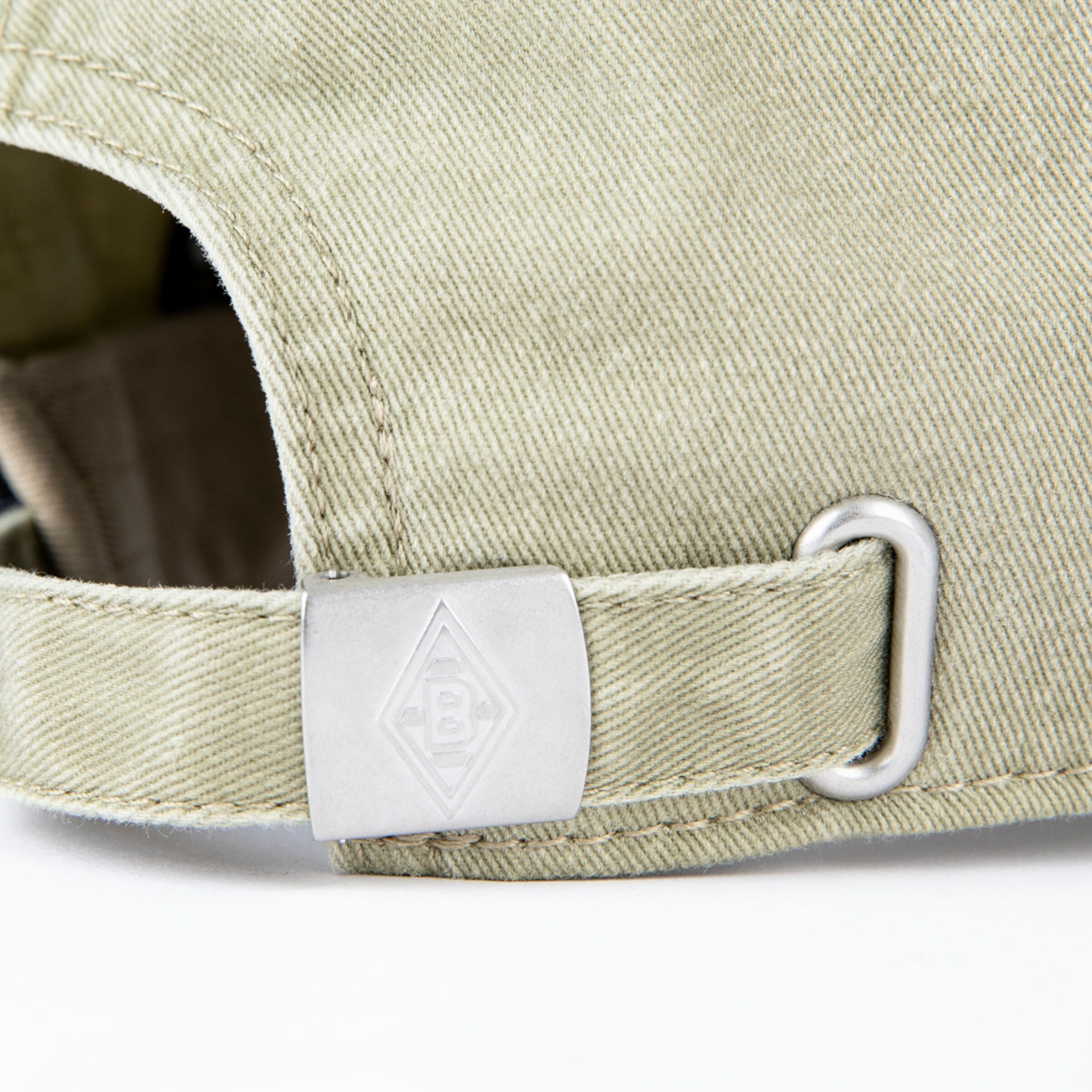Verstellbarer Riemen eines Khaki-Caps mit Metallclip und Borussia Mönchengladbach-Logo.