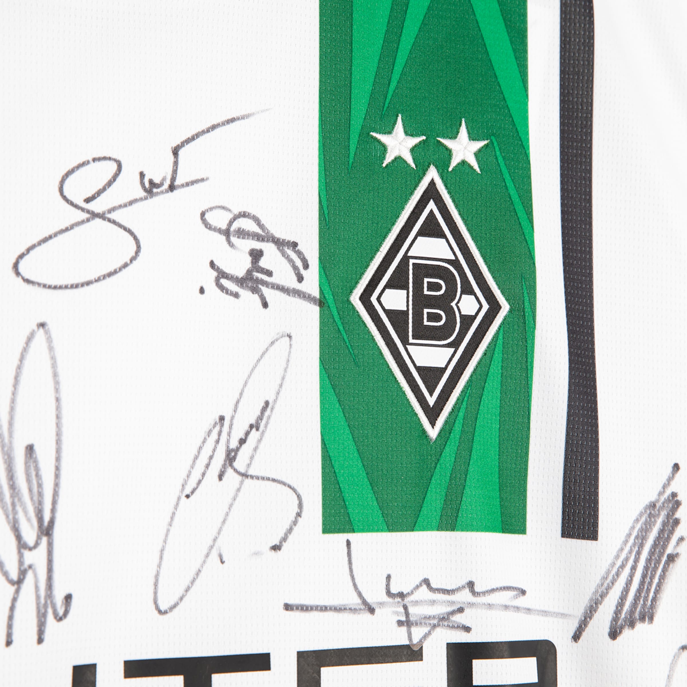 Close-up of a signed white Borussia Mönchengladbach jersey with its logo on a green stripe and several black ink autographs.