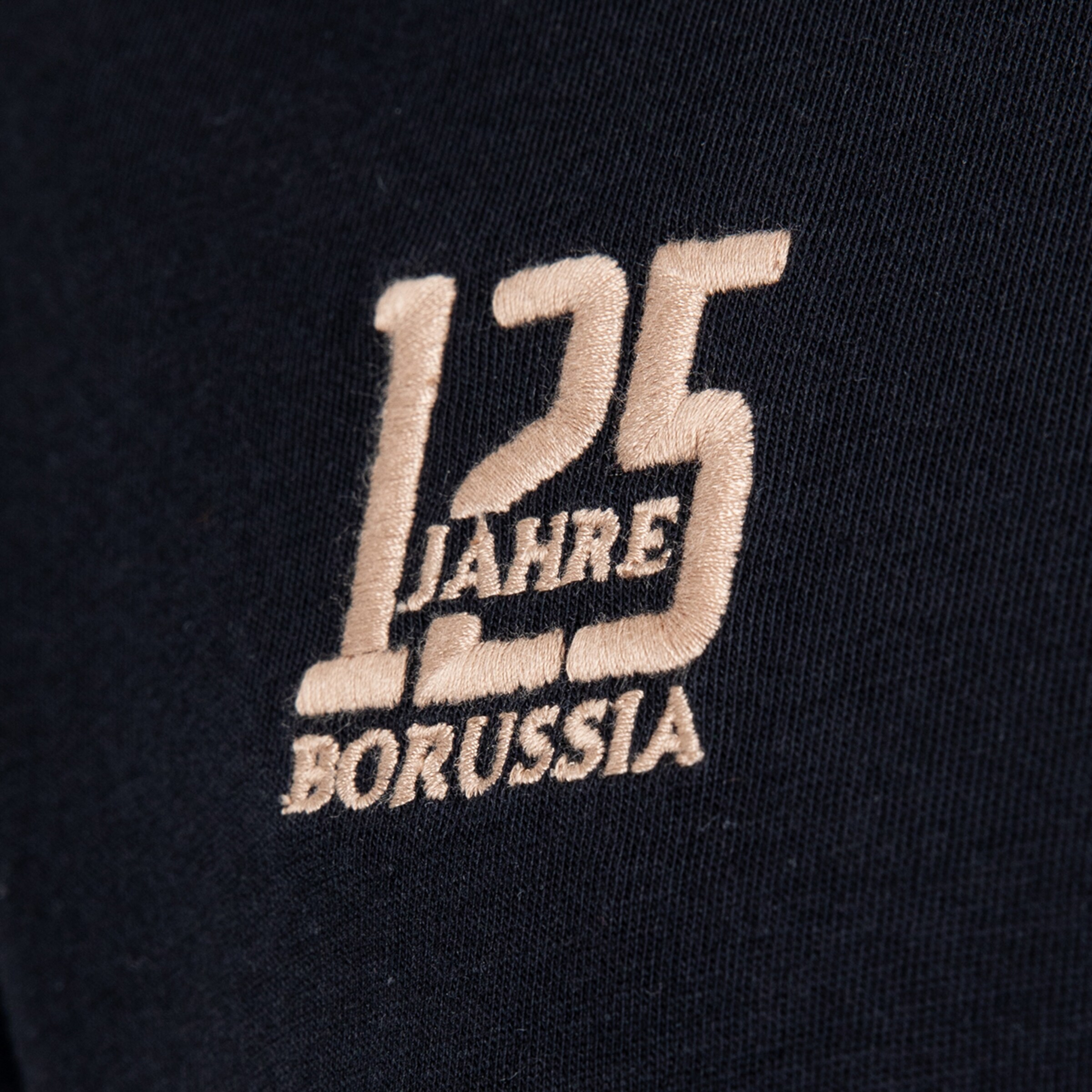 Goldfarbene Stickerei auf dunklem Stoff: Eine große „125“ mit dem Schriftzug „JAHRE“ in der Mitte und „BORUSSIA“ darunter.