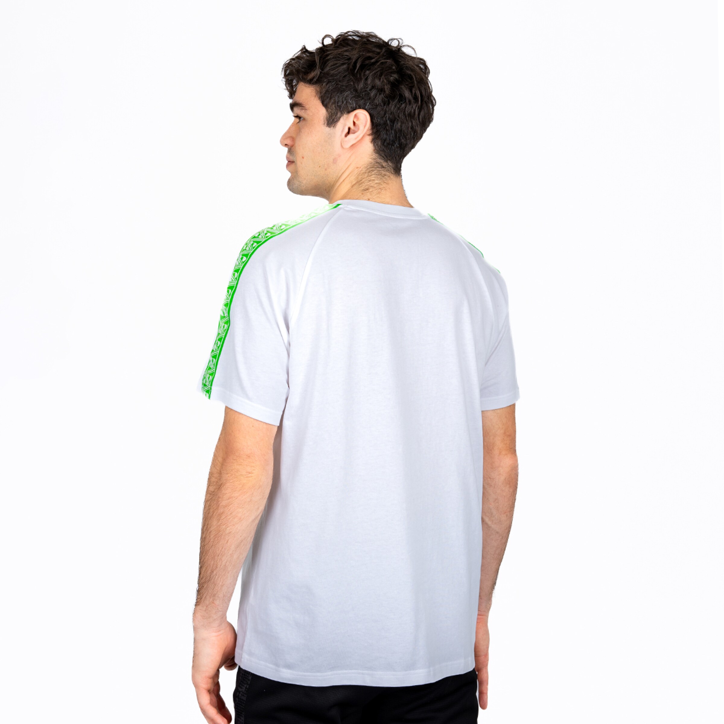 Back view of a man wearing a white t-shirt with green patterned stripes on the shoulders against a white background.