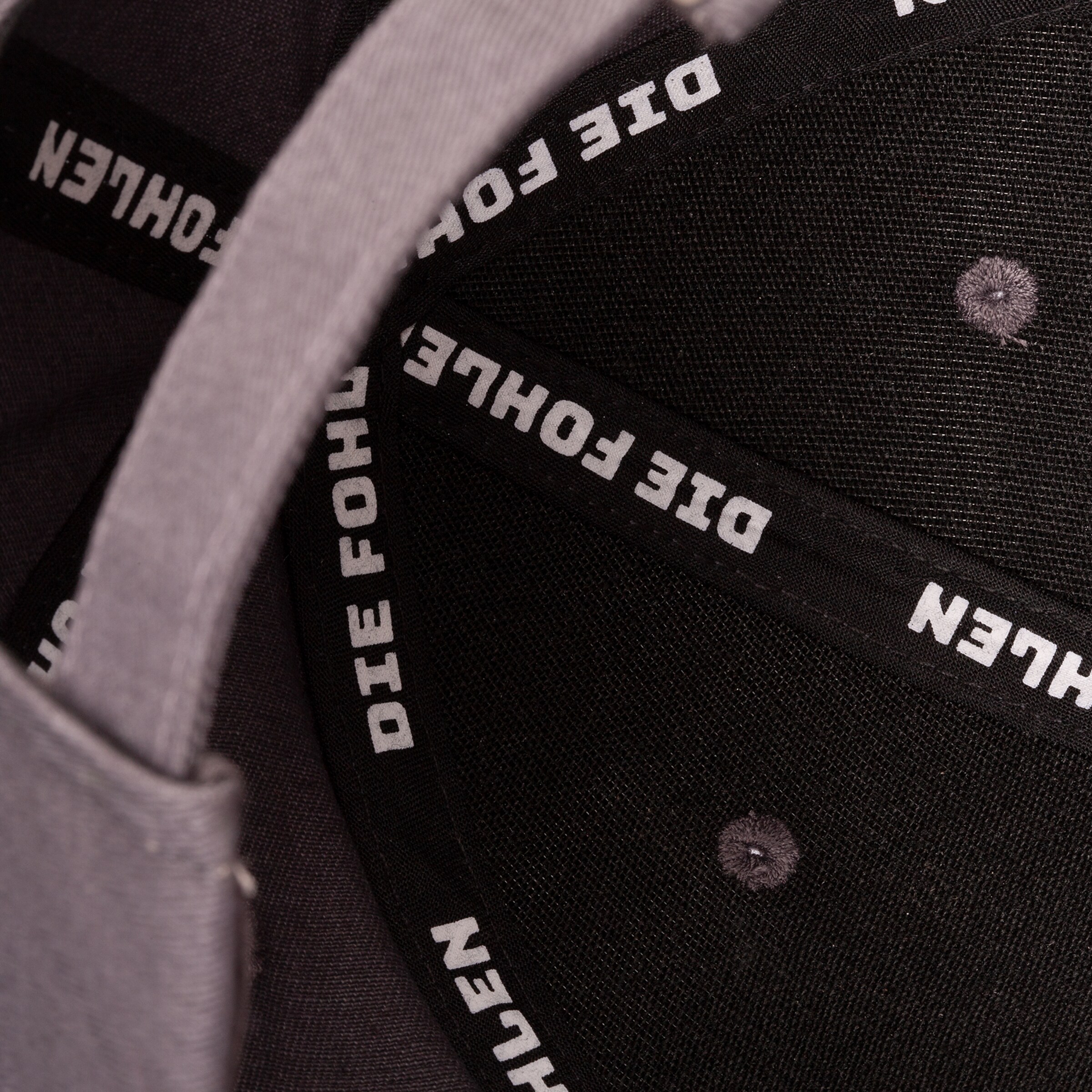 Innenseite einer grauen Mütze mit dem Schriftzug DIE FOHLEN