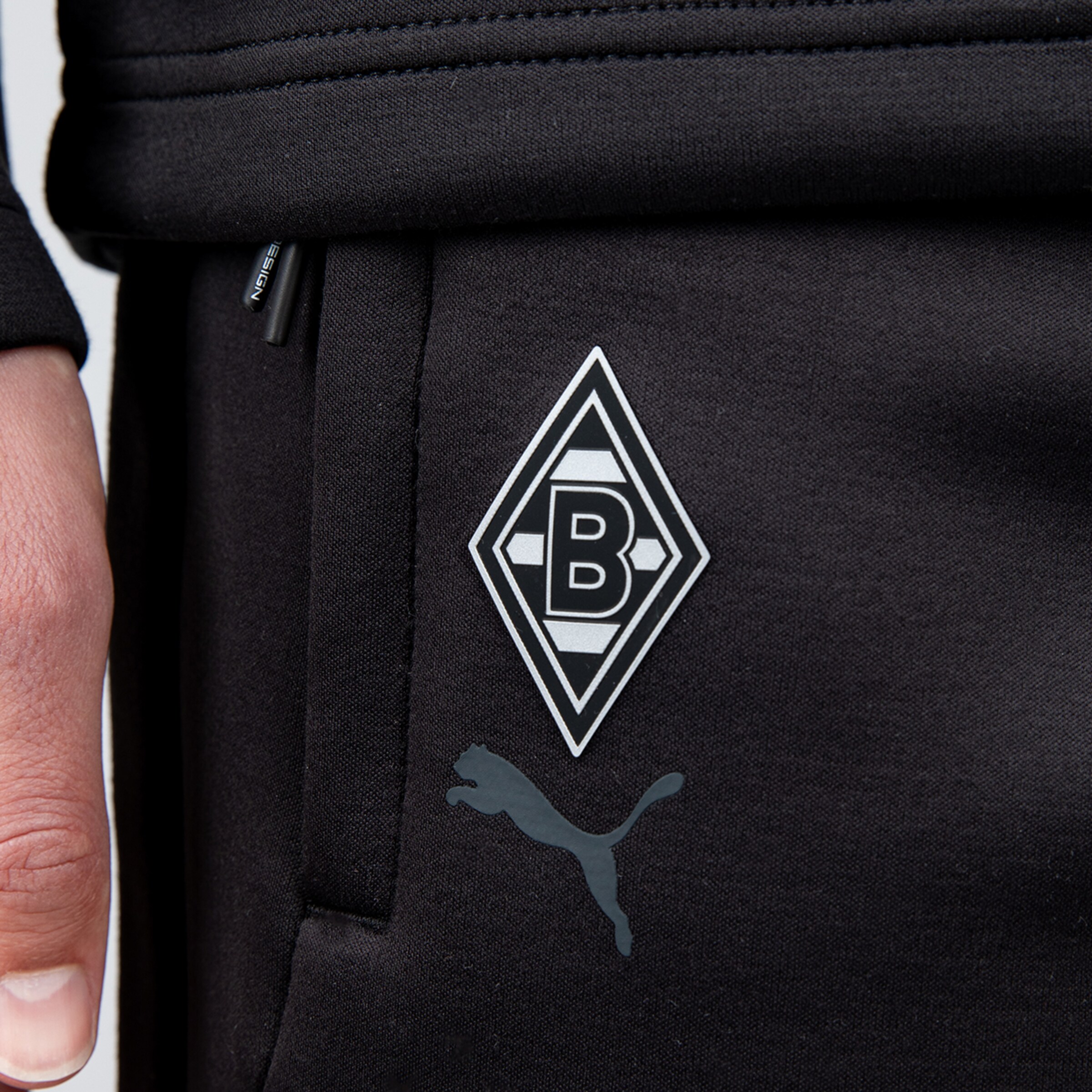 Schwarze Trainingshose mit Borussia Mönchengladbach-Logo und Puma-Symbol.