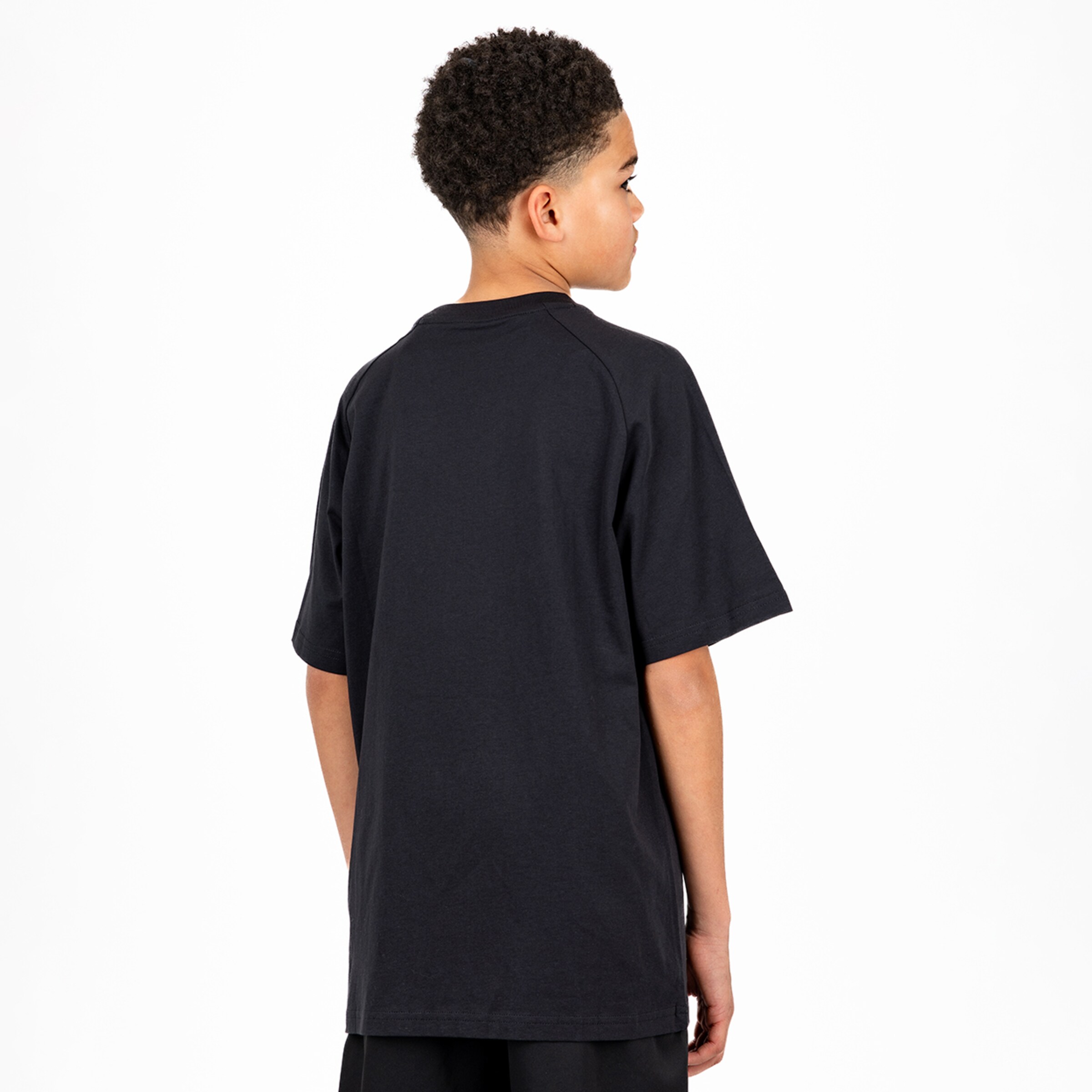 Junge zeigt das Rückenteil eines schwarzen T-Shirts.