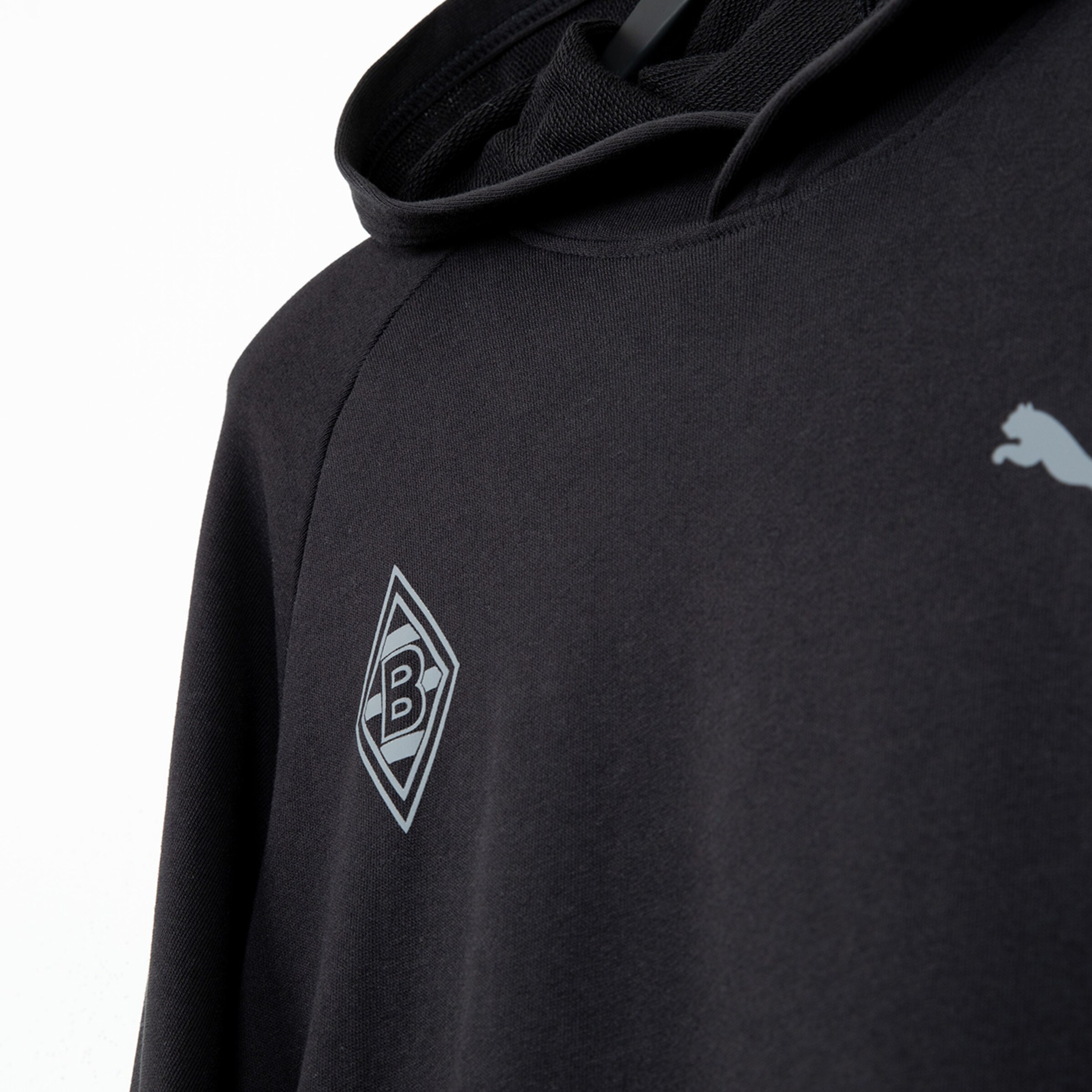 Schwarze Kapuzenjacke mit grauem Borussia Mönchengladbach-Logo und Puma-Emblem.