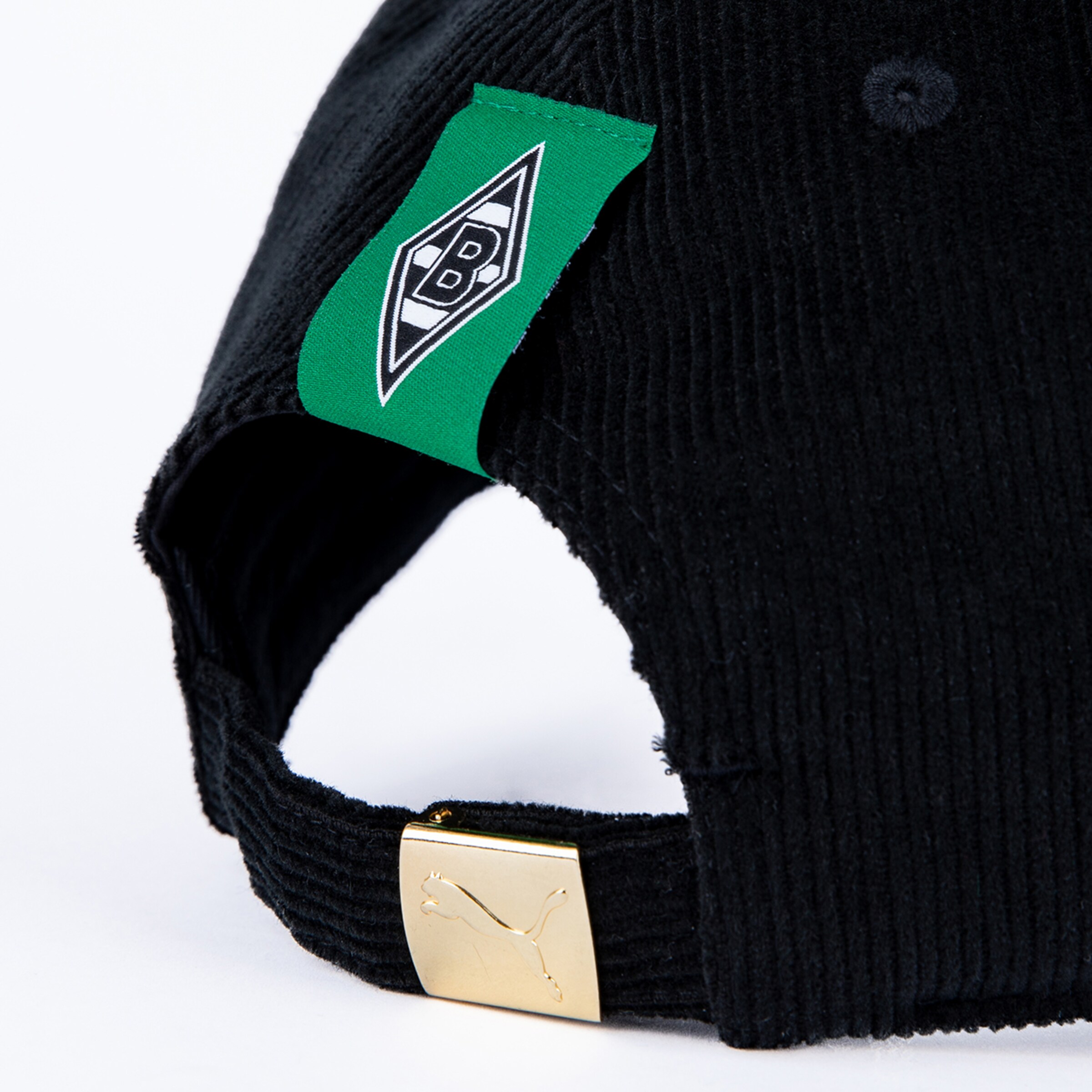 Rückansicht einer schwarzen Cord-Cap mit grünem Borussia-Mönchengladbach-Etikett und goldener Puma-Schnalle.