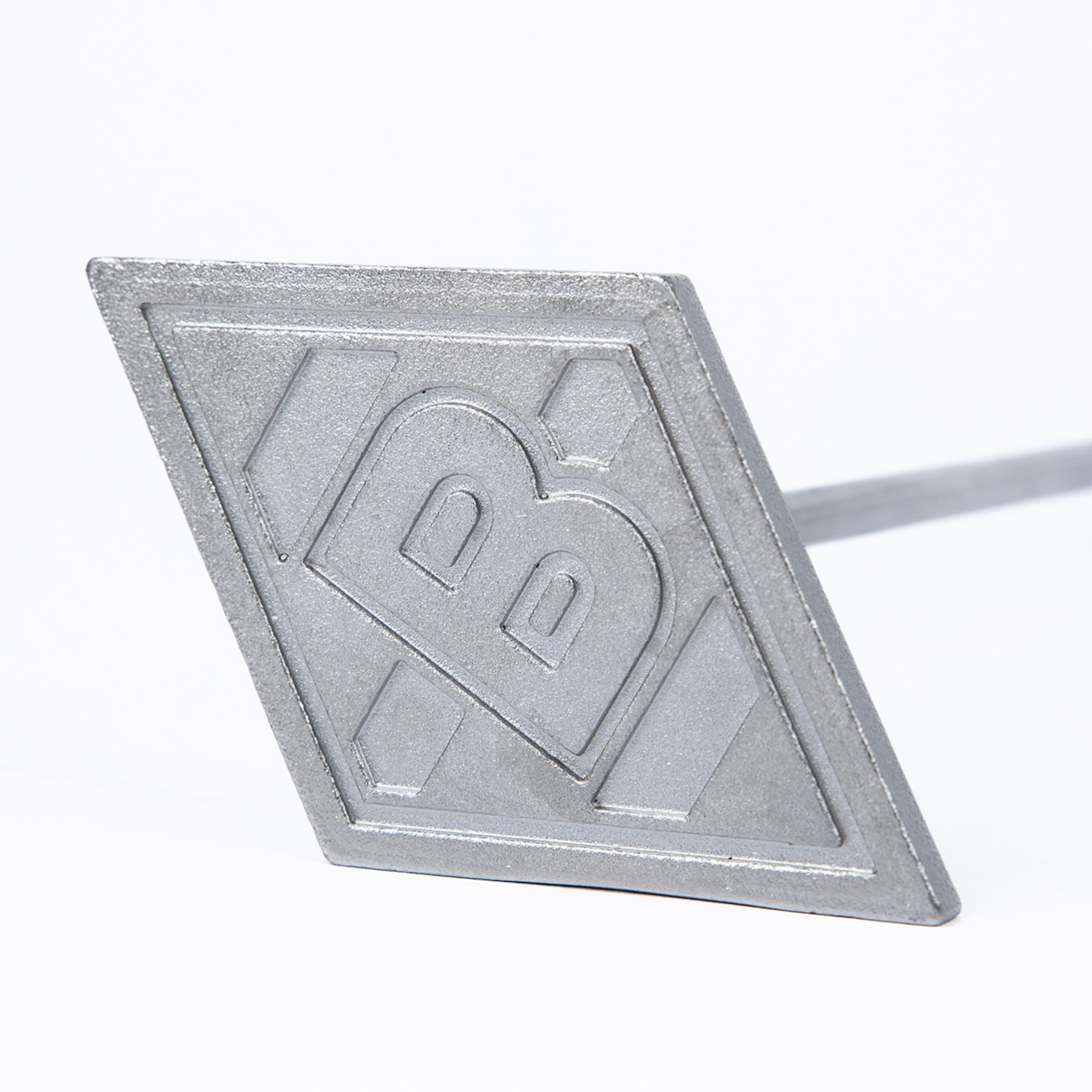 Silbernes Grill-Brandeisen in Rautenform mit dem Logo des Fußballvereins Borussia Mönchengladbach auf weißem Grund.