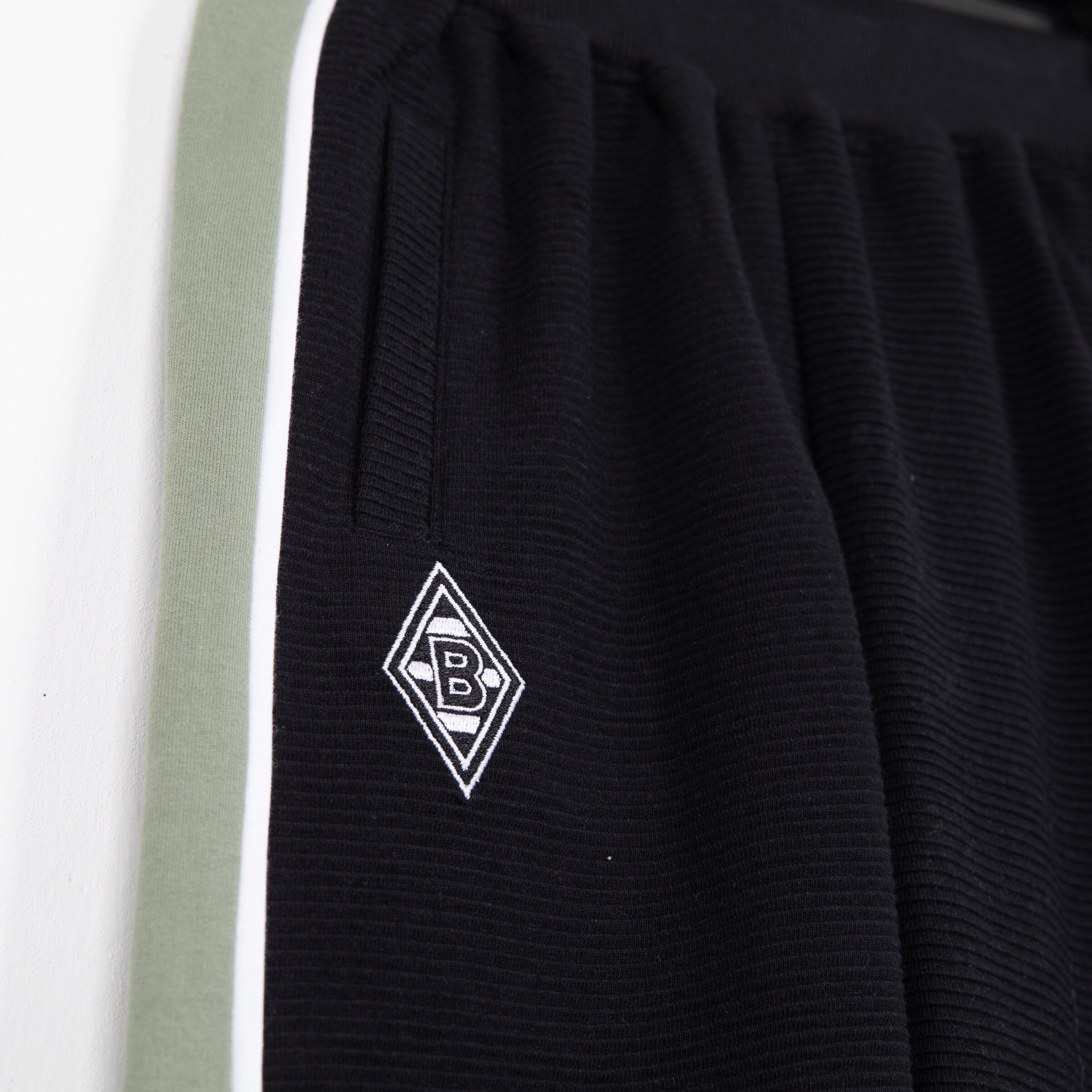 Schwarze Sporthose mit gestreiftem Muster und B-Logo von Borussia Mönchengladbach.