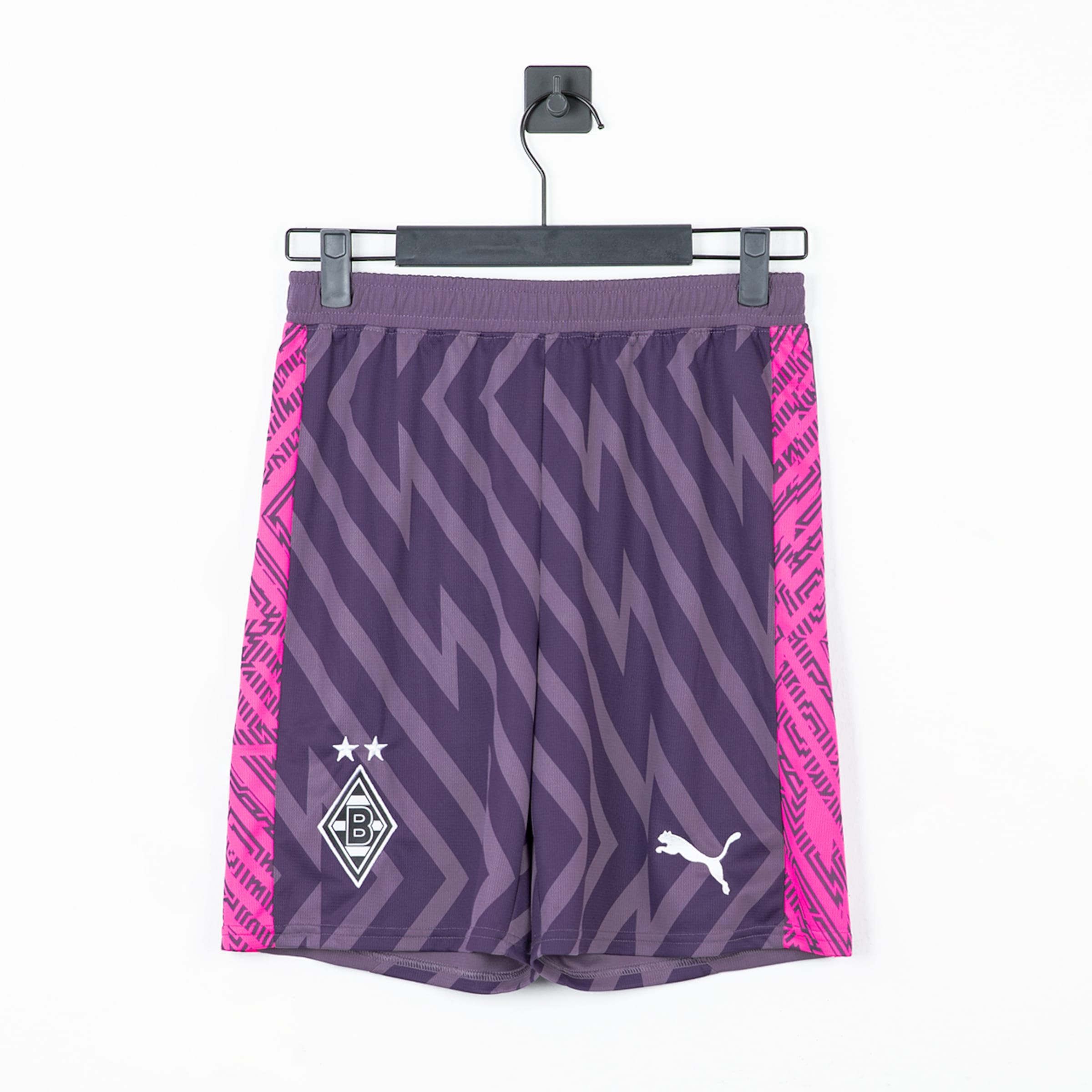 Lila Fußballshorts mit Zickzack-Muster, pinken Seitenstreifen, weißem Puma-Logo und Borussia Mönchengladbach-Wappen.