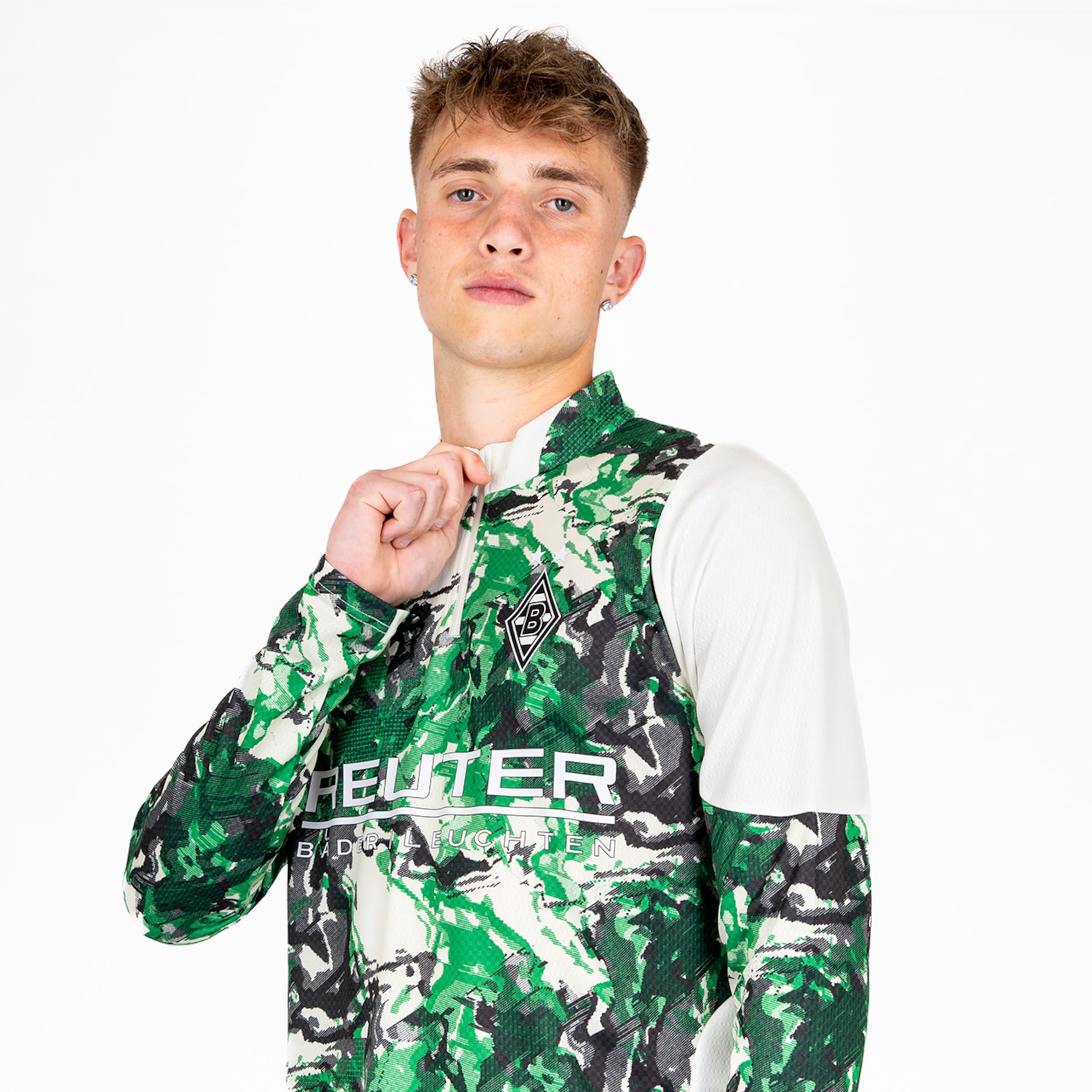 Ein Spieler von Borussia Mönchengladbach trägt ein modernes Trikot mit einem camo-artigen Muster und posiert.